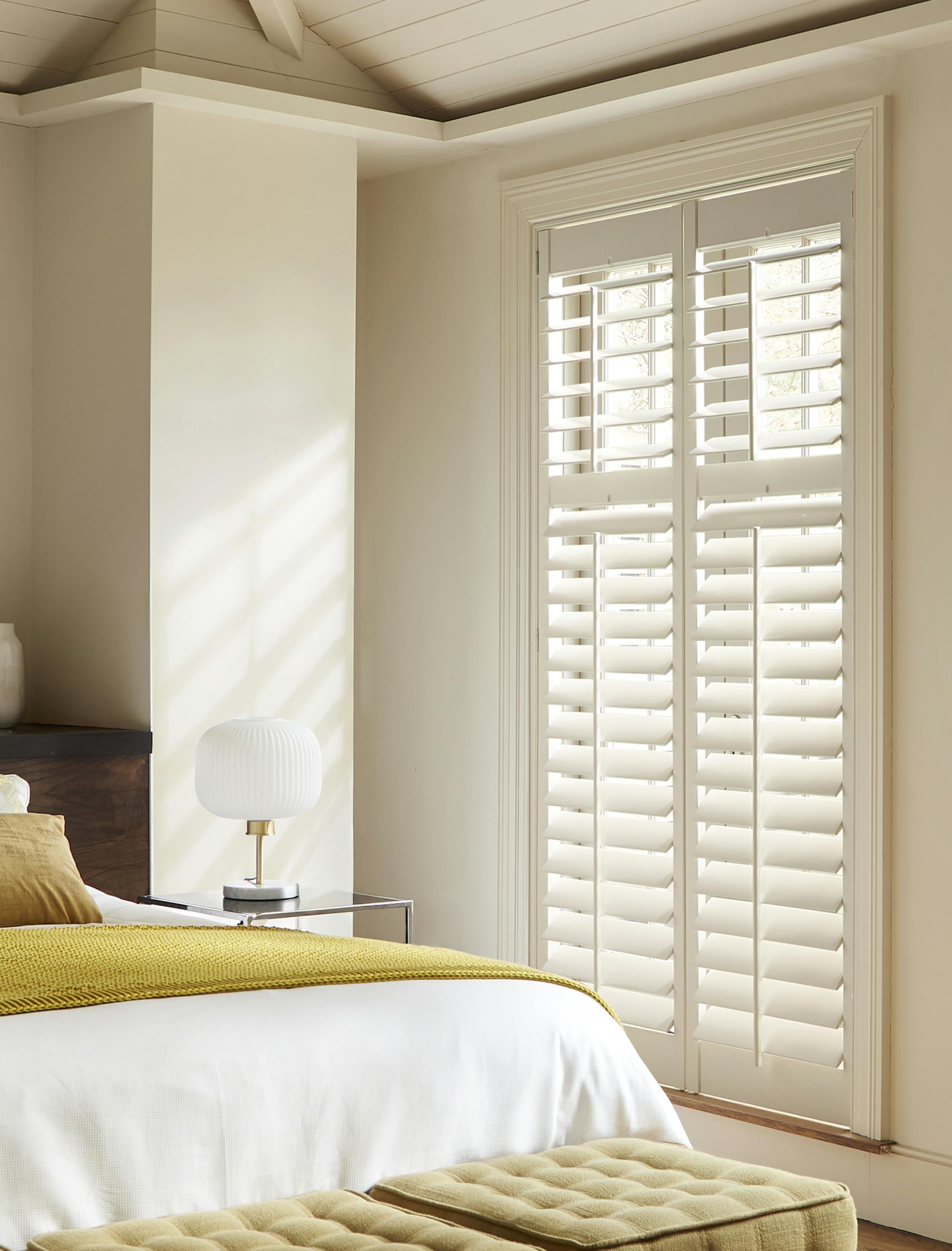 White shutters on a window in a modern bedroom