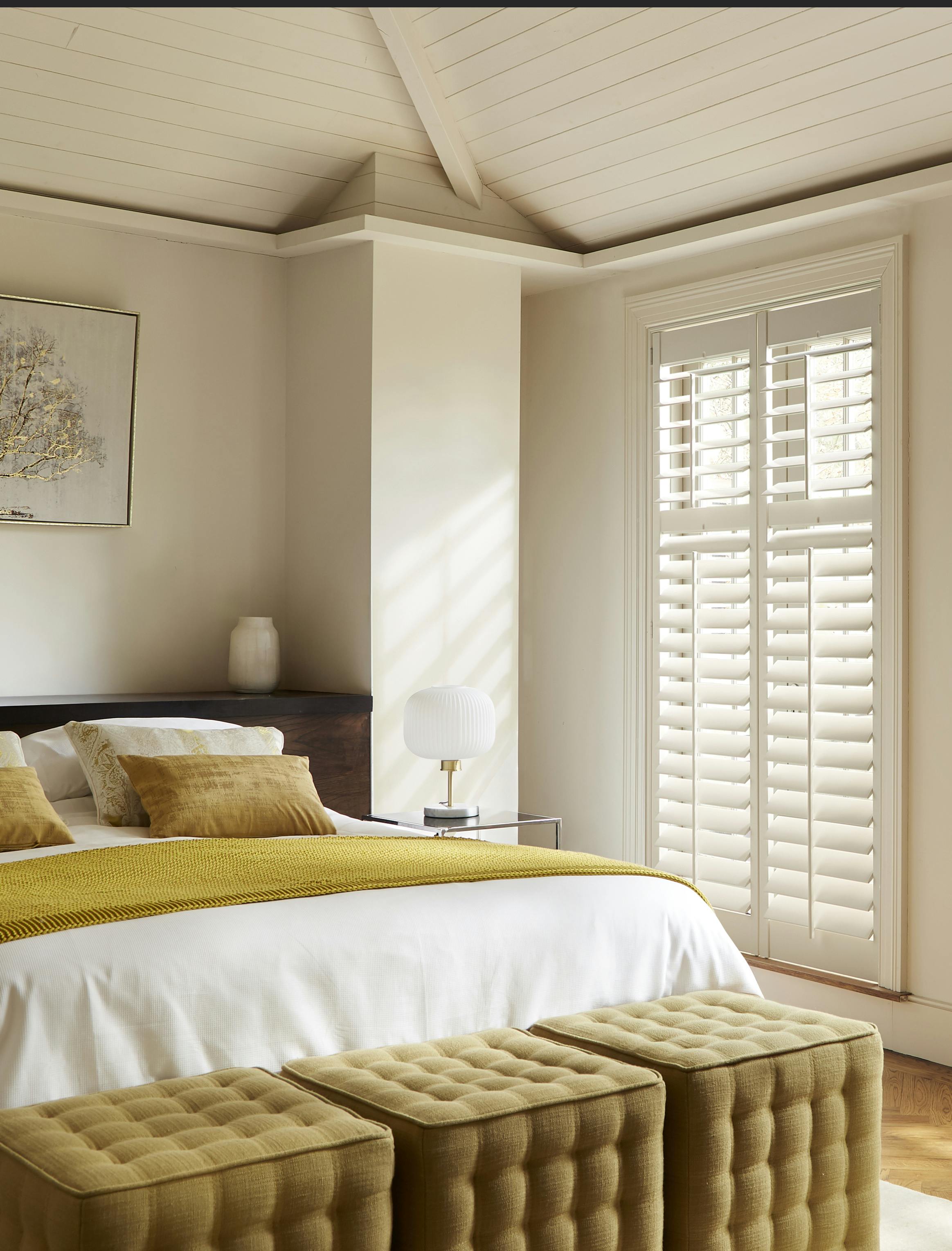 Witte shutters op een raam in een moderne slaapkamer