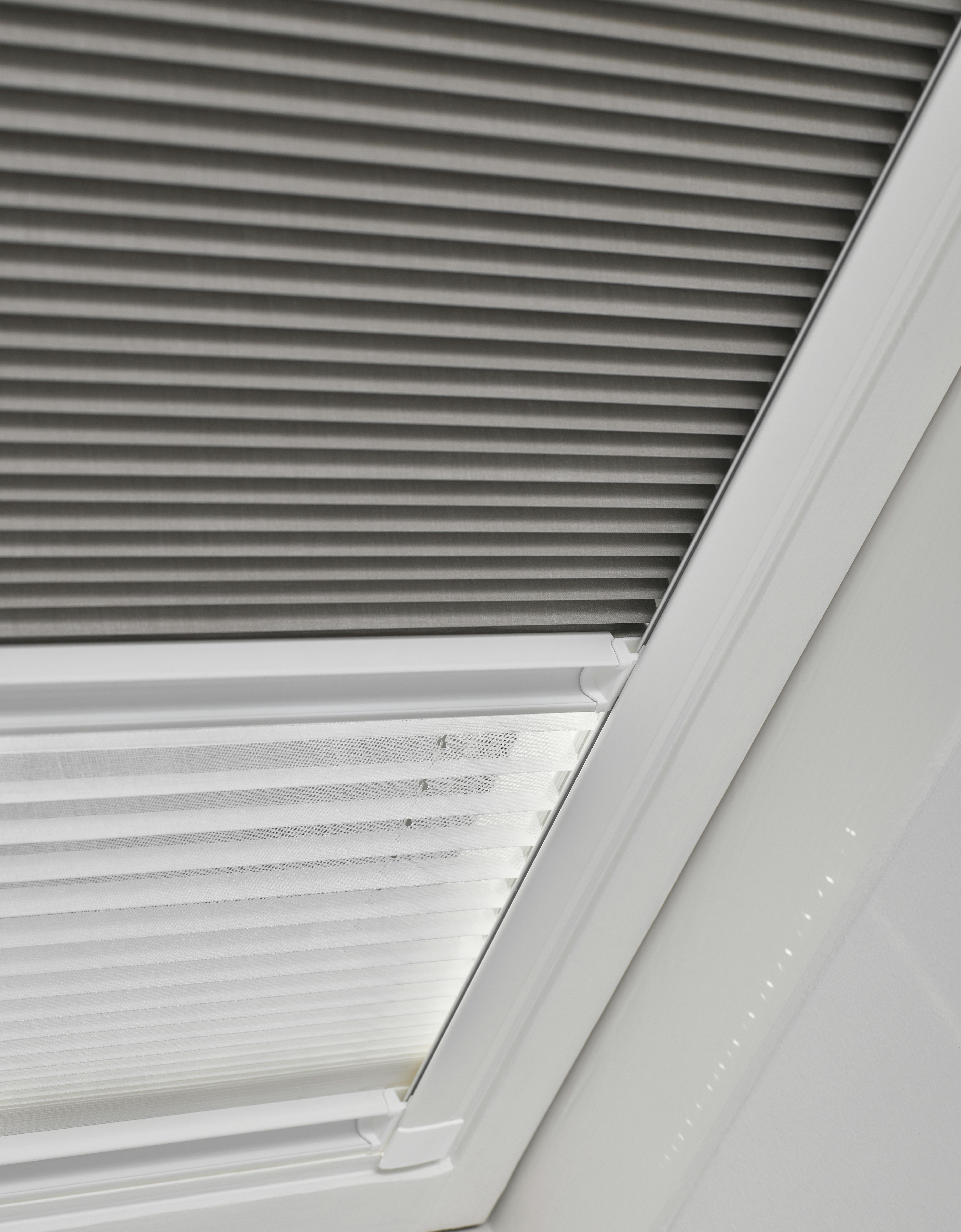 Closeup of grey day and night Duette shades on a skylight window