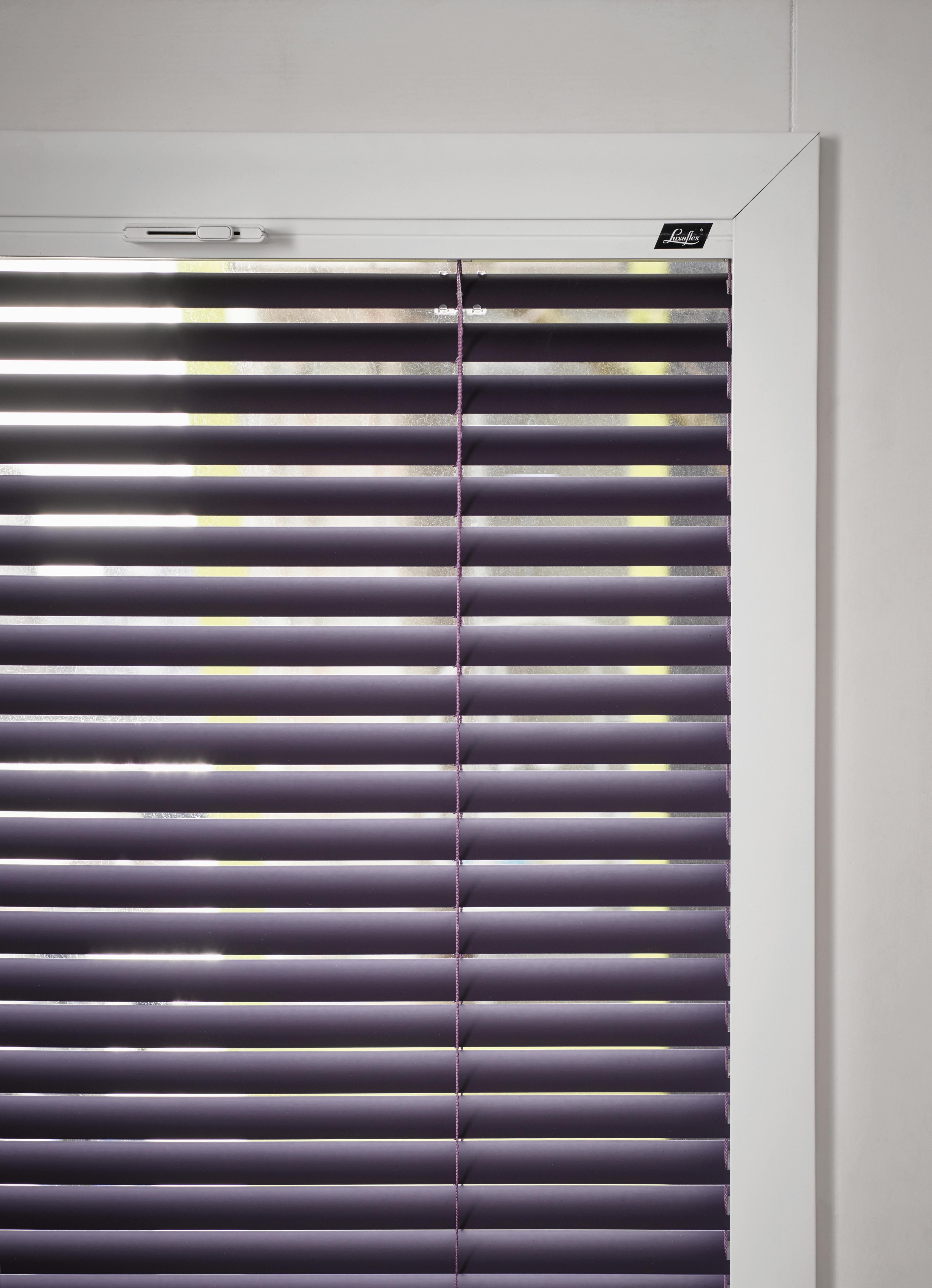 Closeup of purple venetian blinds on a tilt and turn window