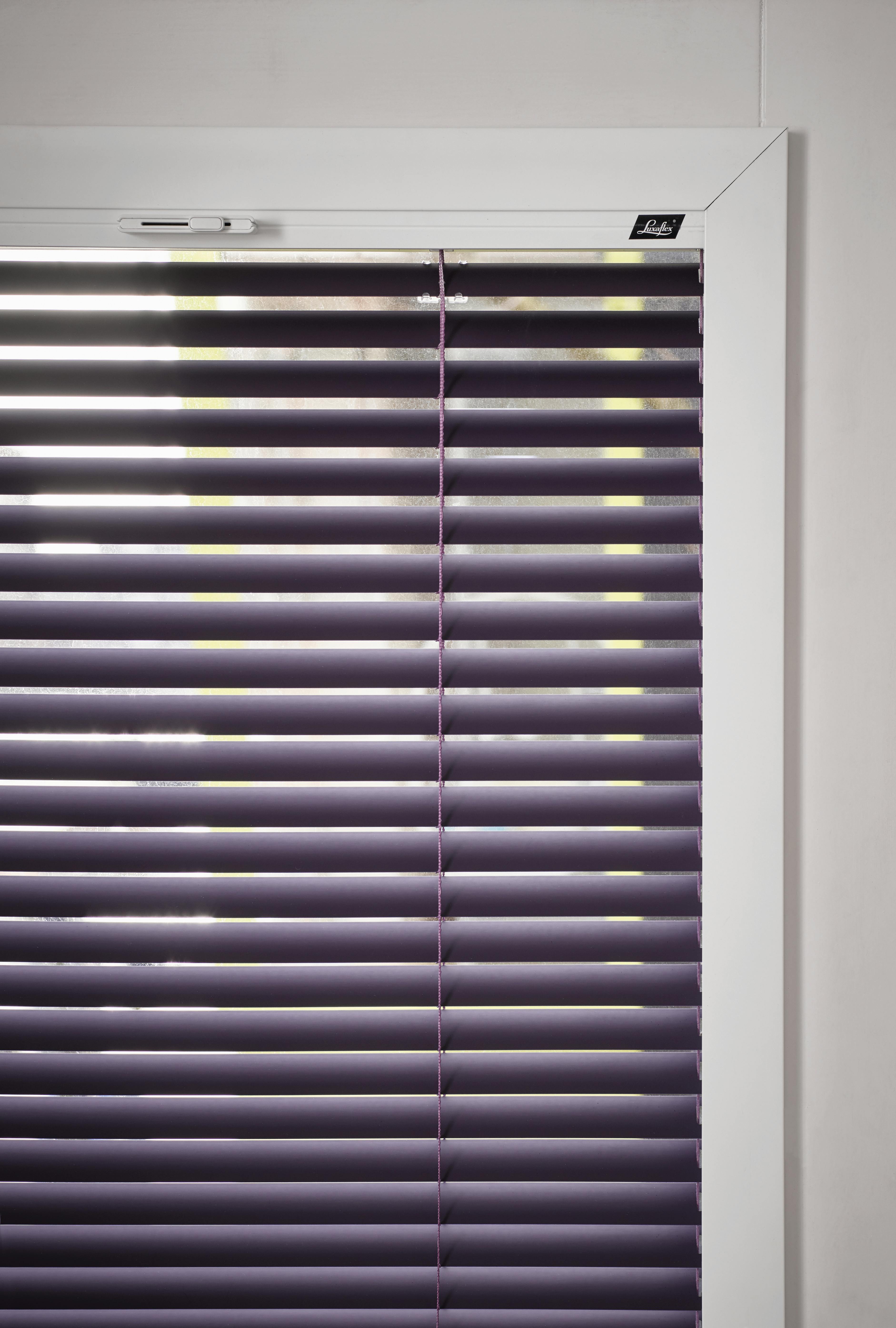Closeup of purple venetian blinds on a tilt and turn window