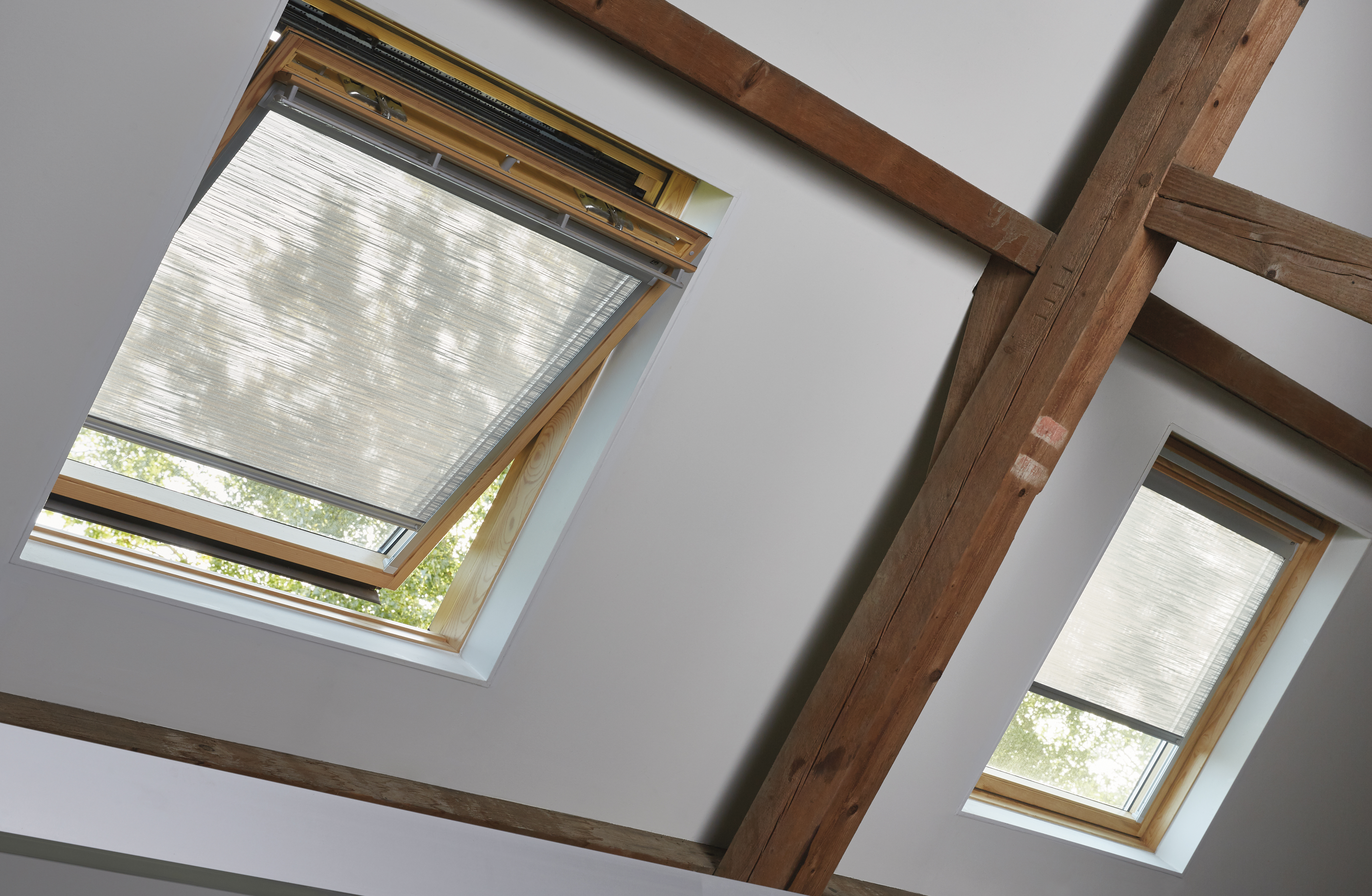 Lichtgrijze, doorschijnende rolgordijnen op dakramen