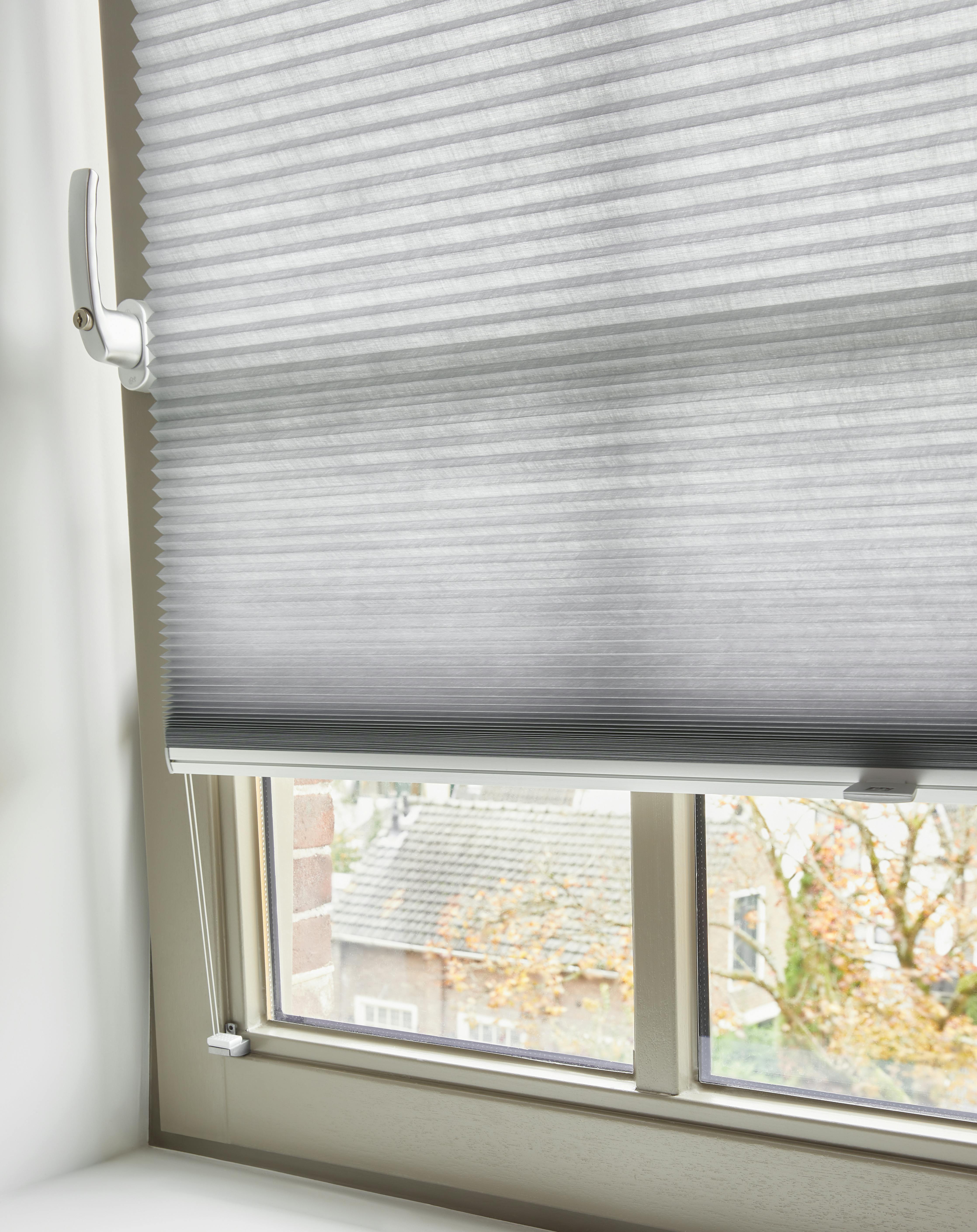 Light grey Duette® shades on a tilt & turn window