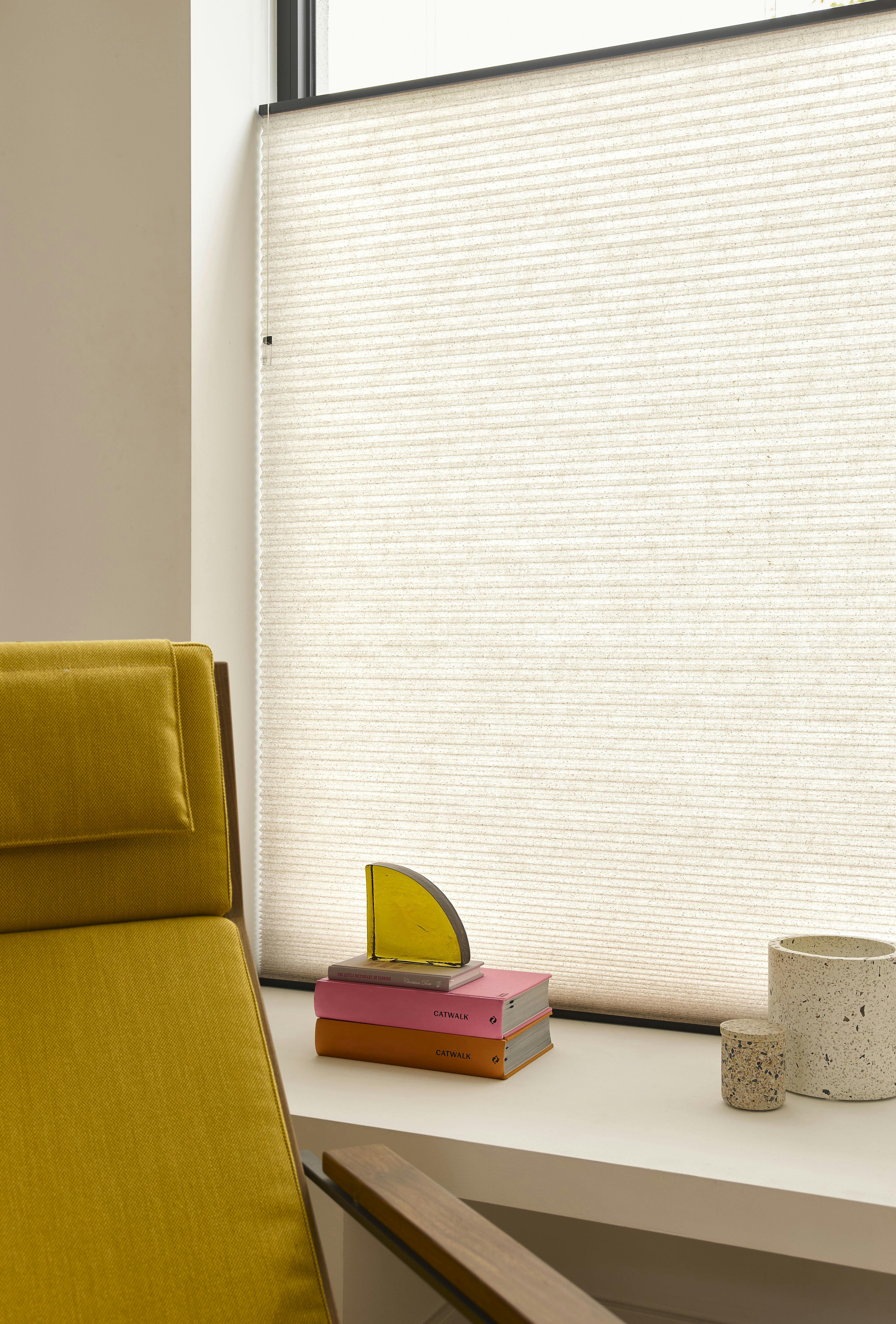 A closeup of orange duette shades in a living room 