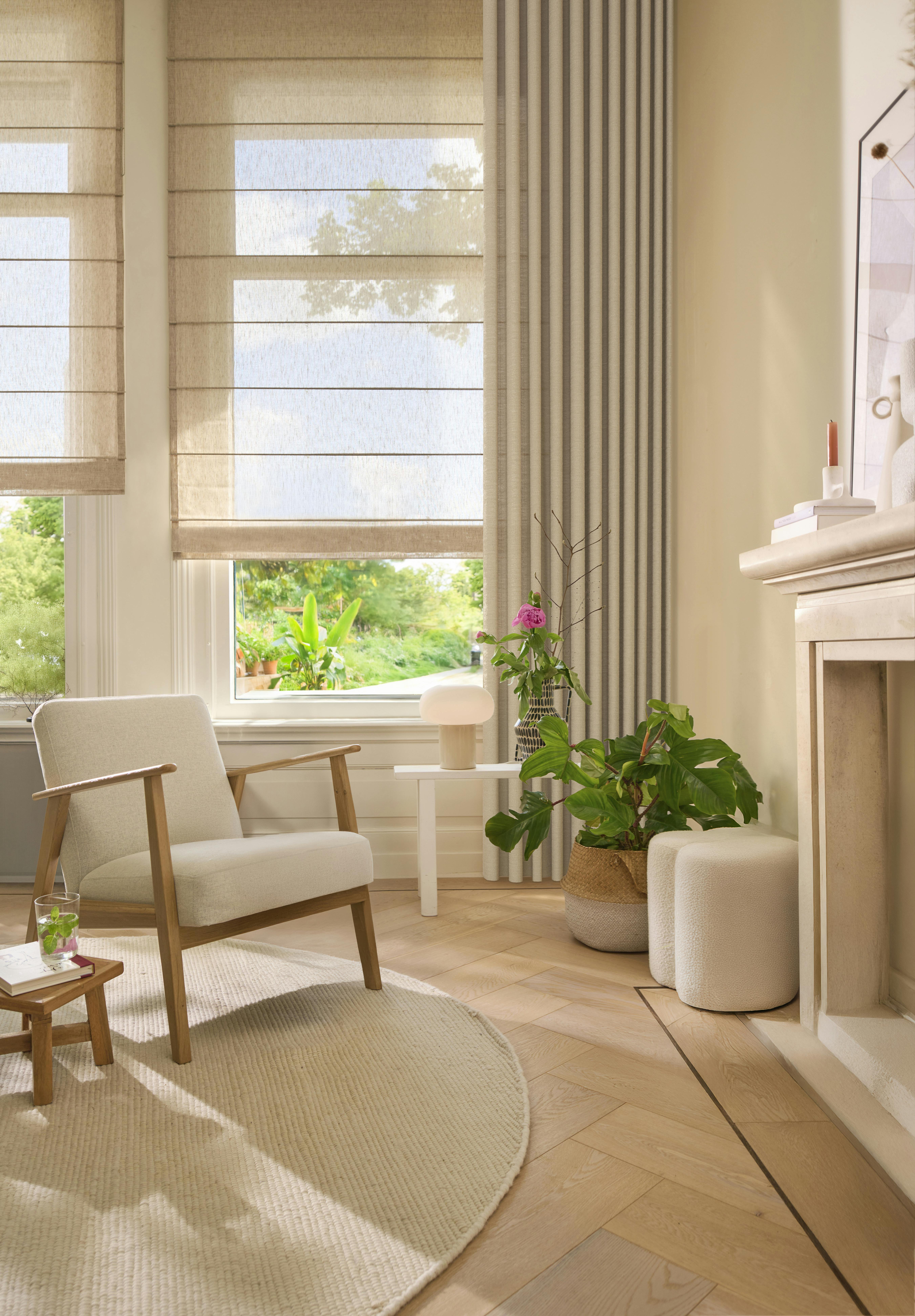 Lys stue med cremefarvede liftgardiner på vinduerne