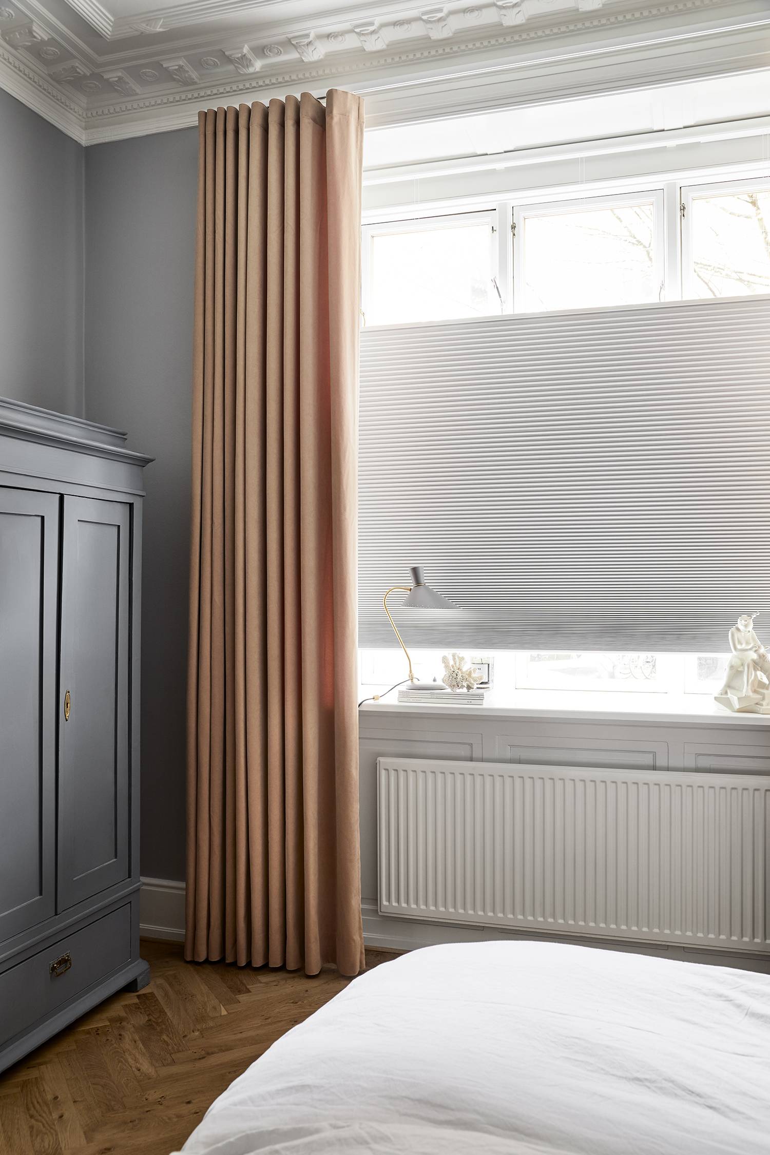 Yellow curtains and white duette shades in a bedroom 