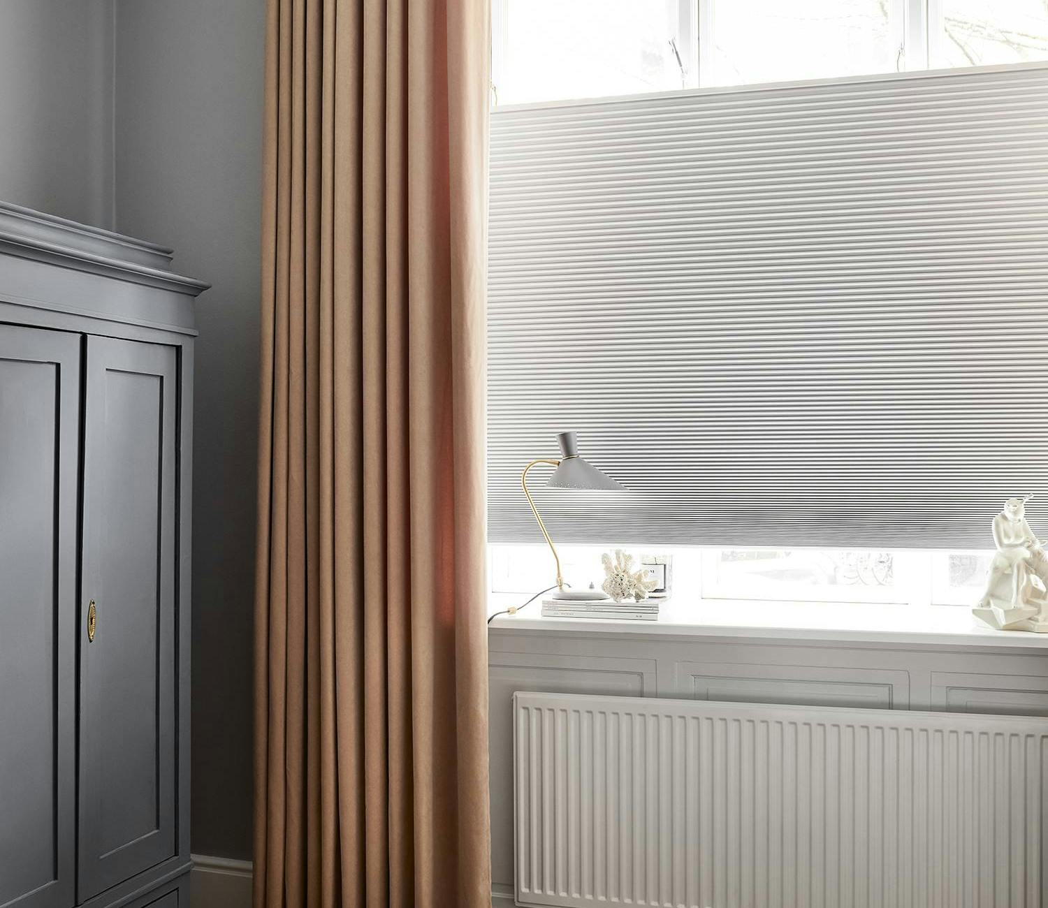 Yellow curtains and white duette shades in a bedroom