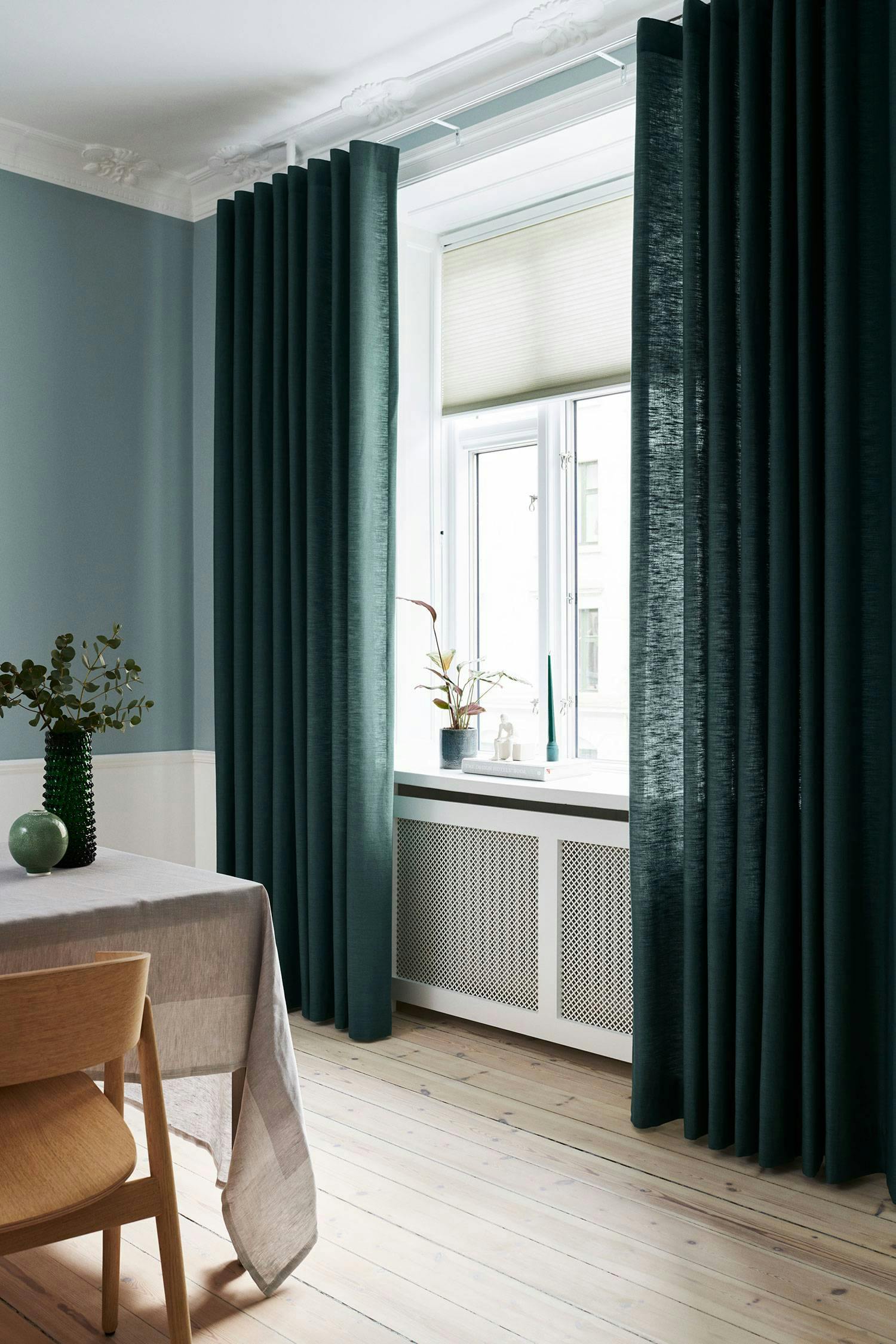 Dark green curtains in a dining room 