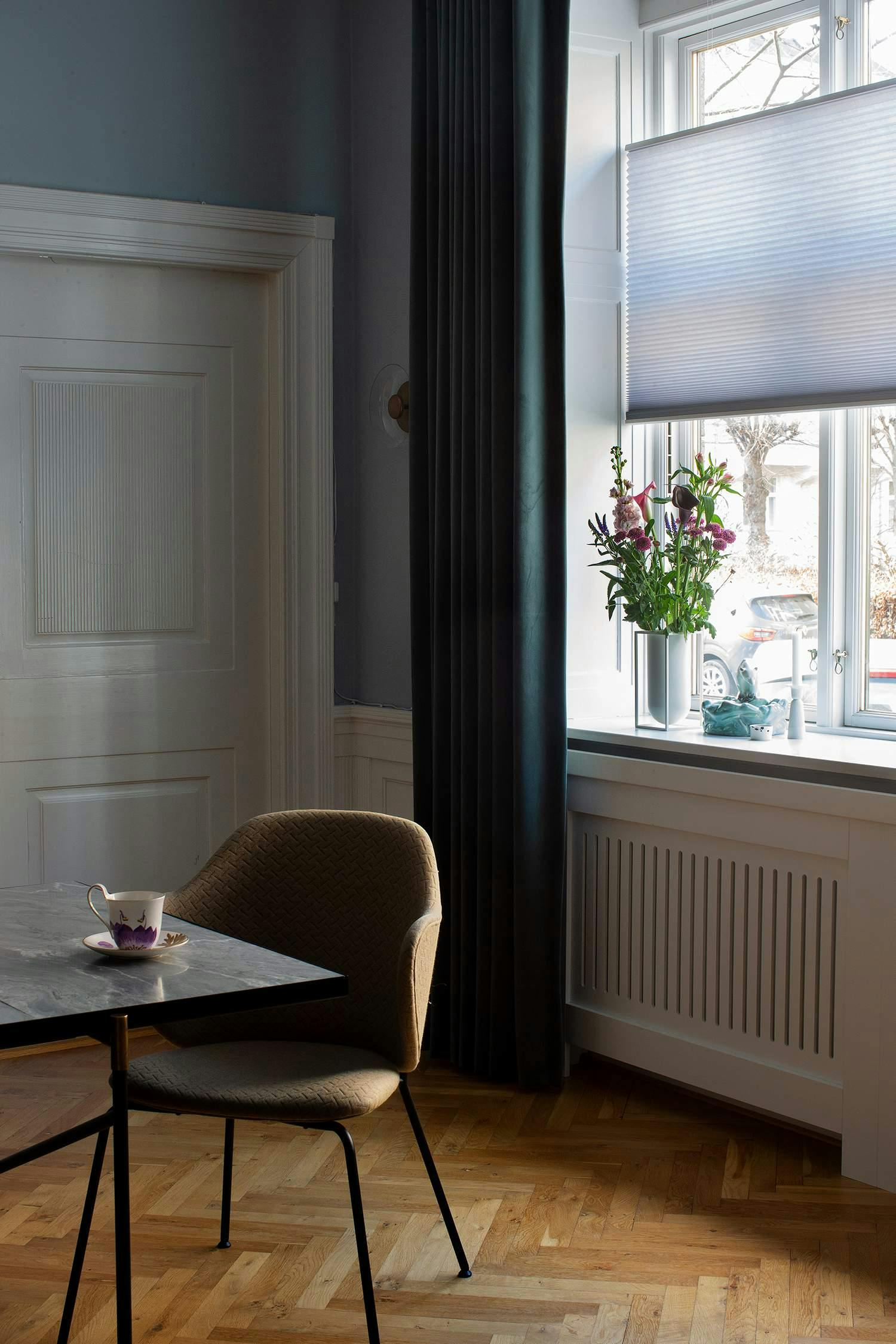 purple duette layered with dark green curtains in a dining room 