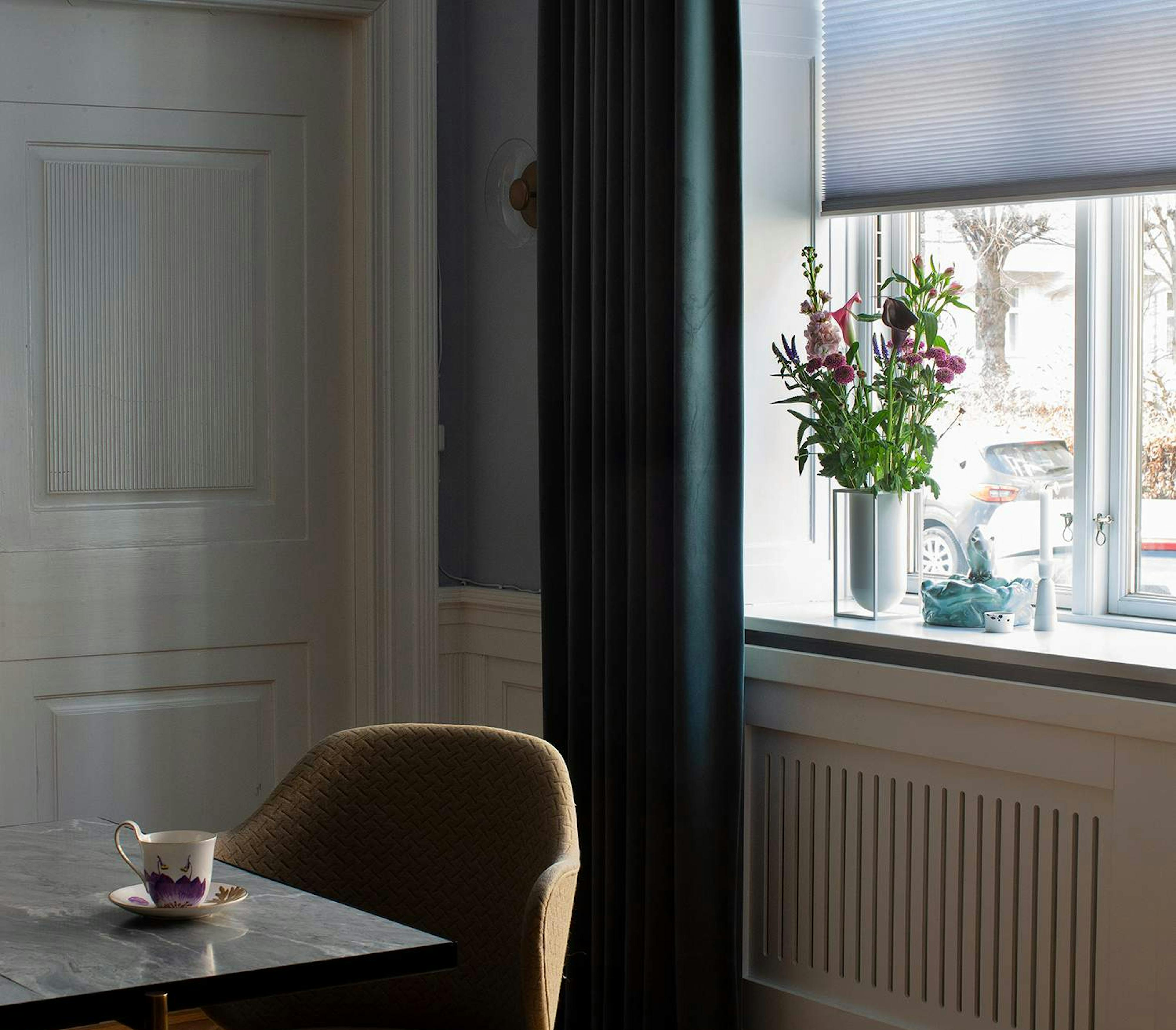 purple duette layered with dark green curtains in a dining room