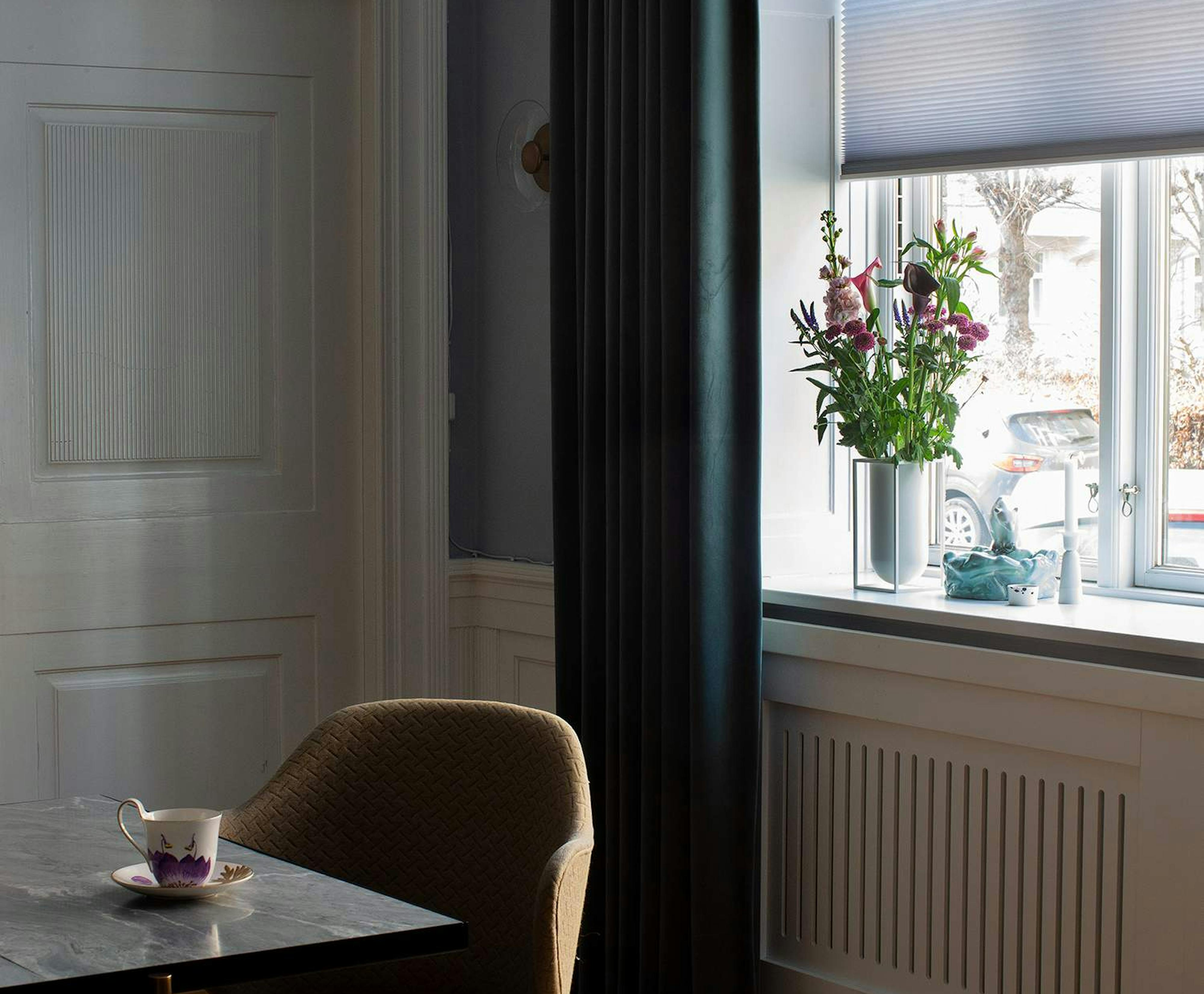 purple duette layered with dark green curtains in a dining room