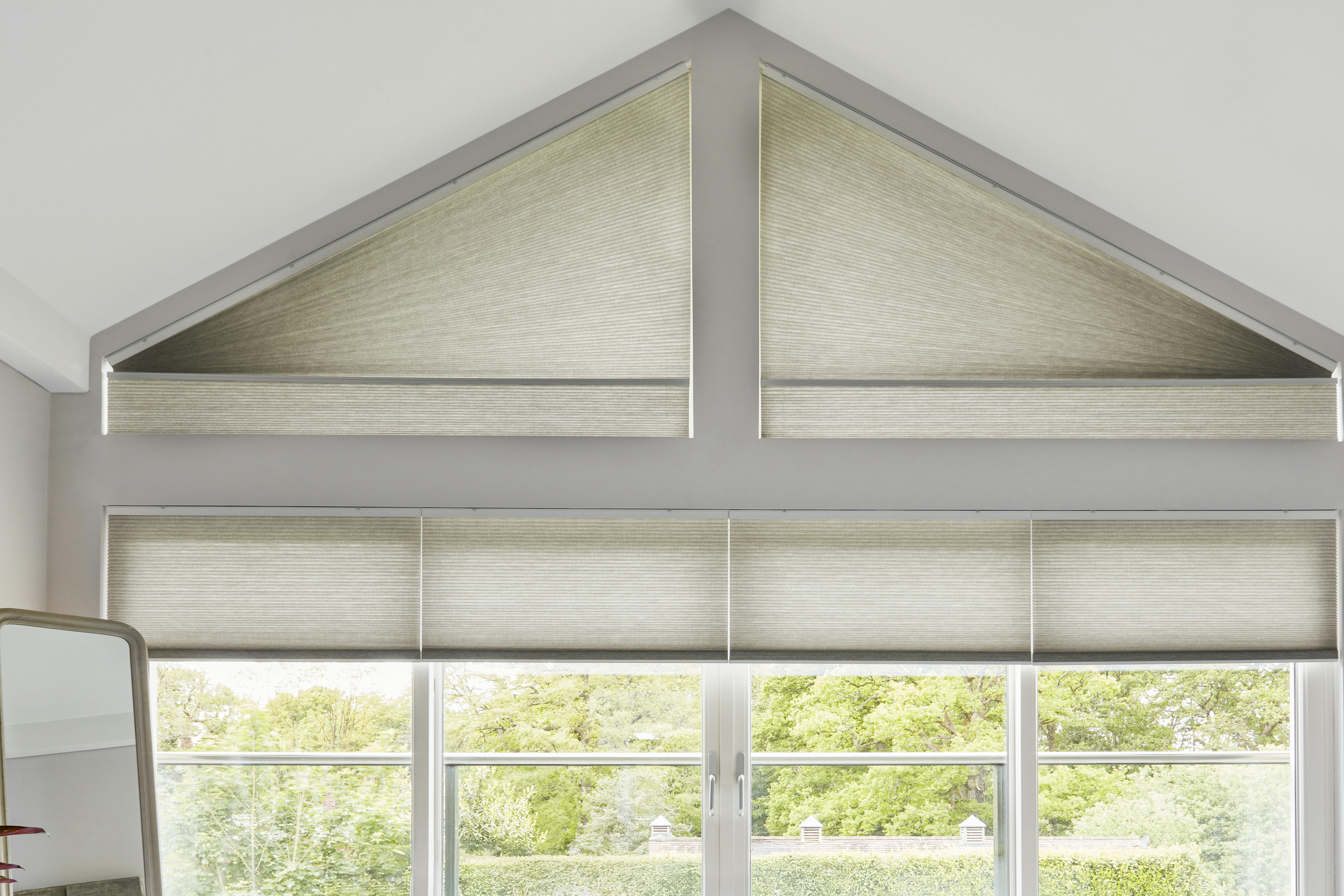 Cream Duette® blinds on large windows and a gable end window in a living room