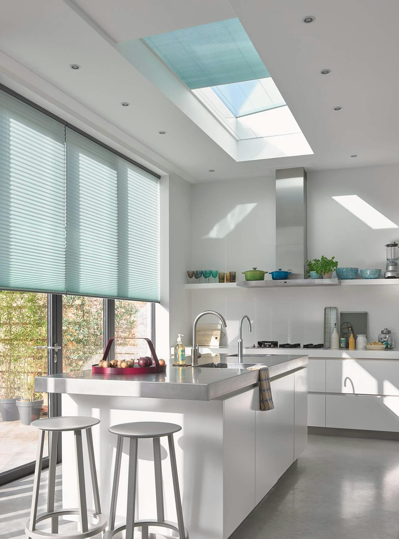 Teal plisse shades on a standard and skylight window in a kitchen 