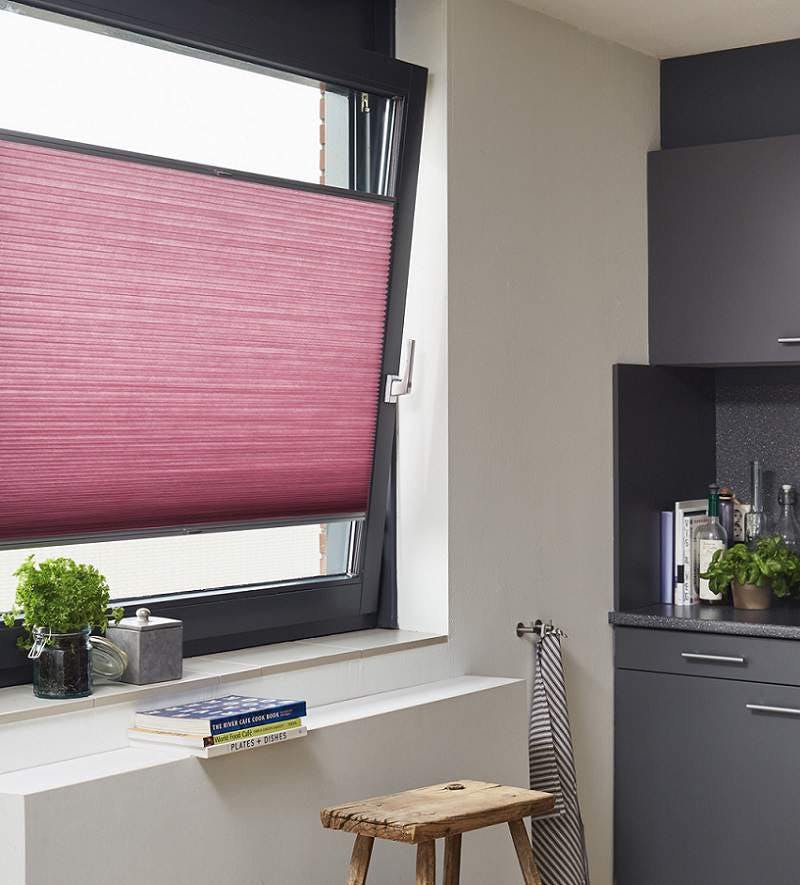 Pink duette shades on a tilt and turn window in a kitchen