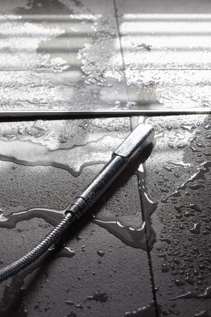 Closeup of a shower head on a bathroom floor