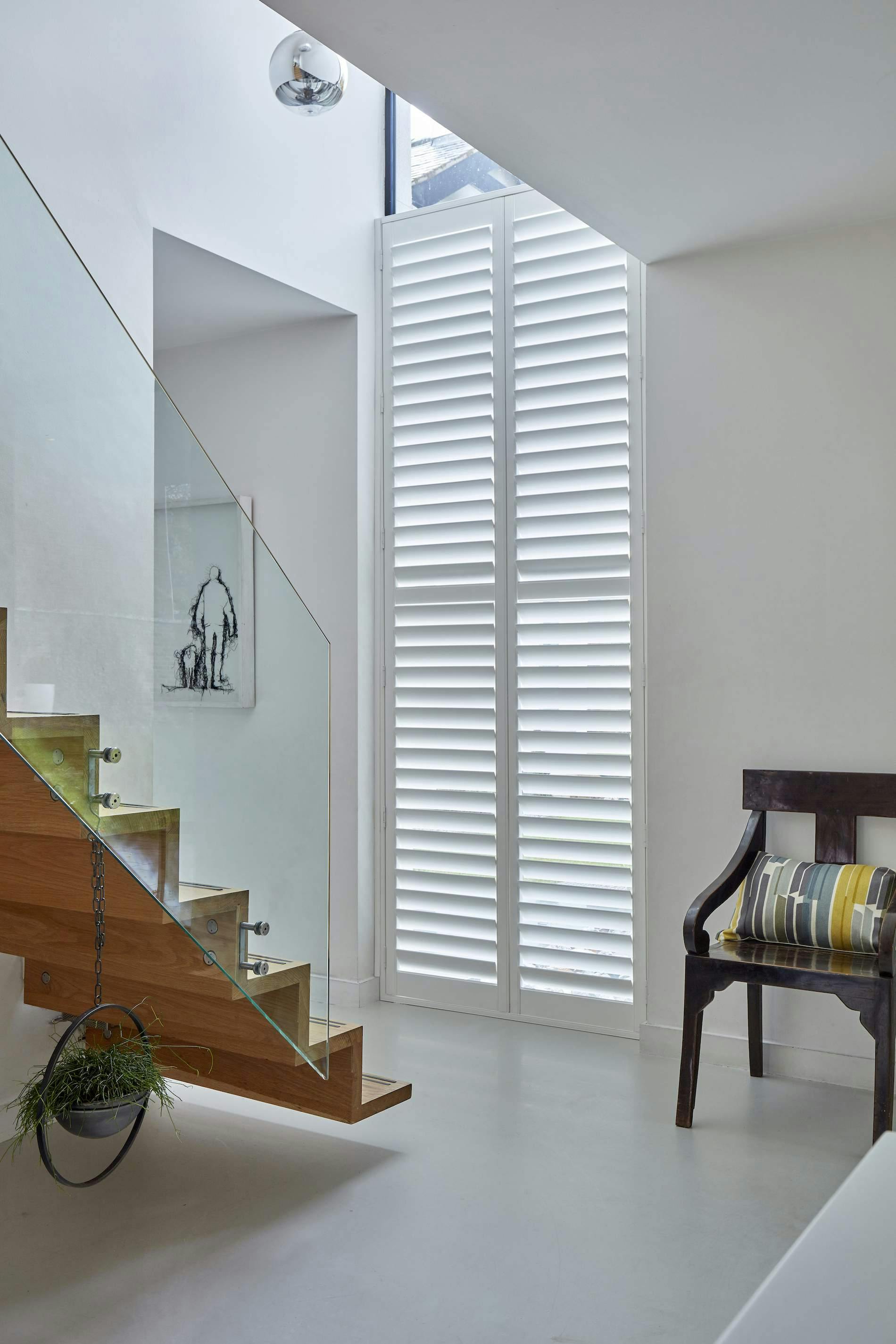 full-height shutters in white on a hallway entrance 