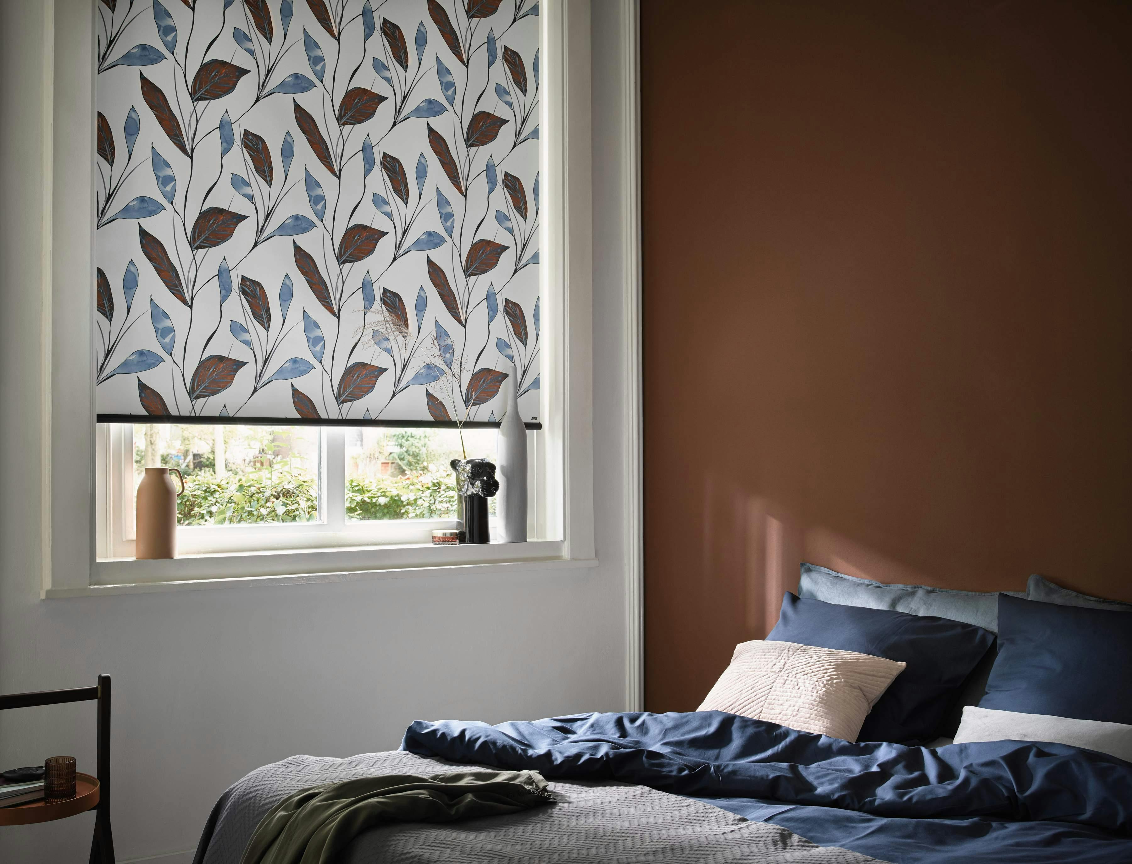 Brown and blue designs on roller blinds in a bedroom