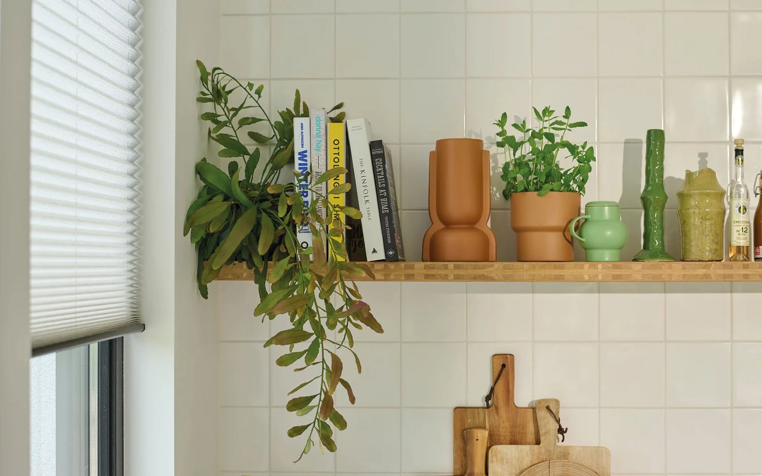 Hvite plisségardiner på et kjøkkenvindu