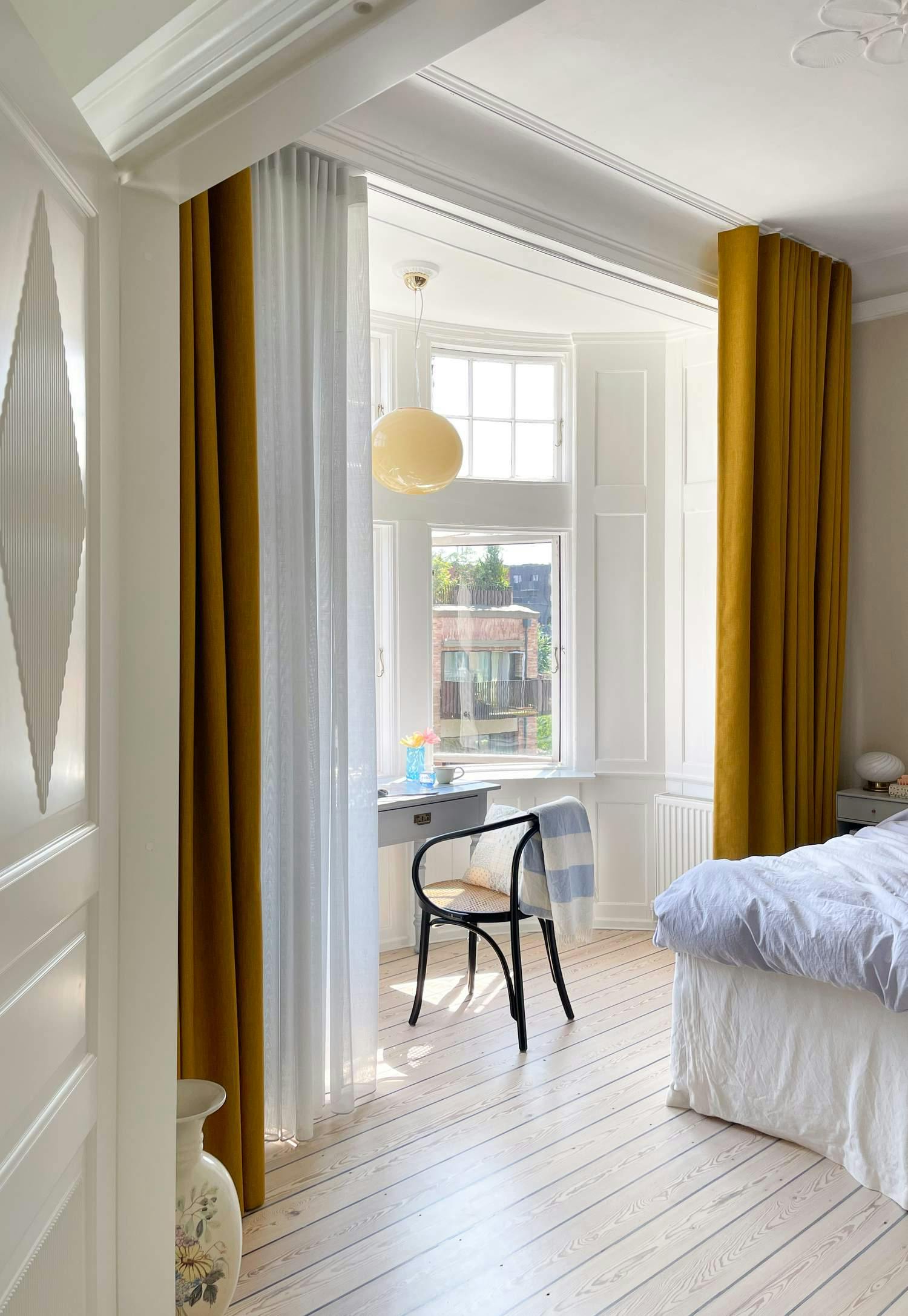 Okkergule gardiner i kombination med lyseblå transparente gardiner