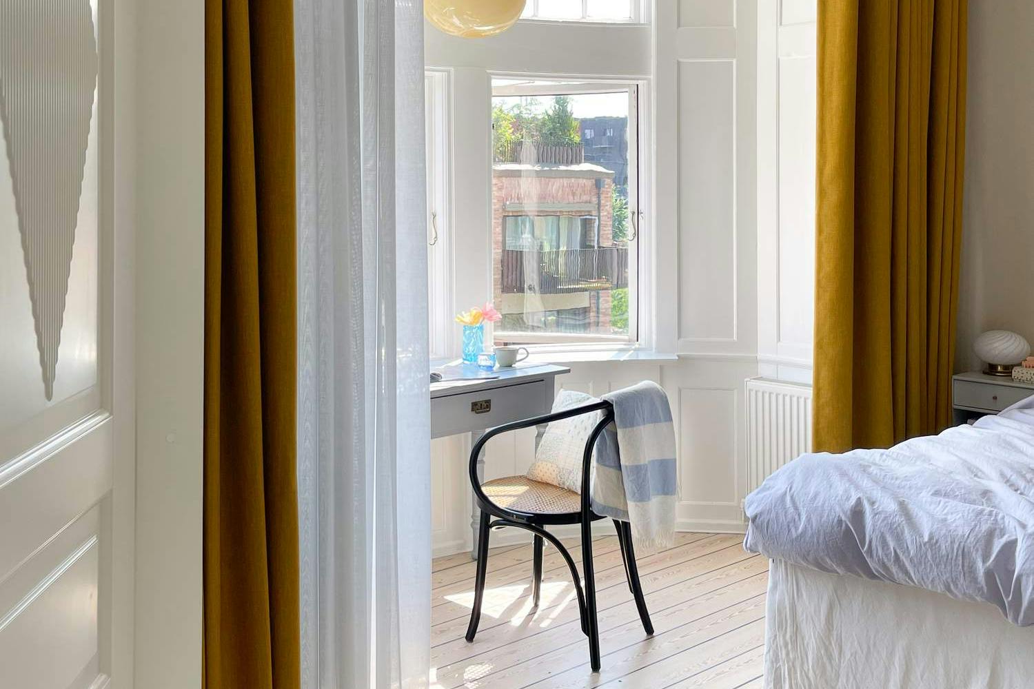 Okkergule gardiner i kombination med lyseblå transparente gardiner