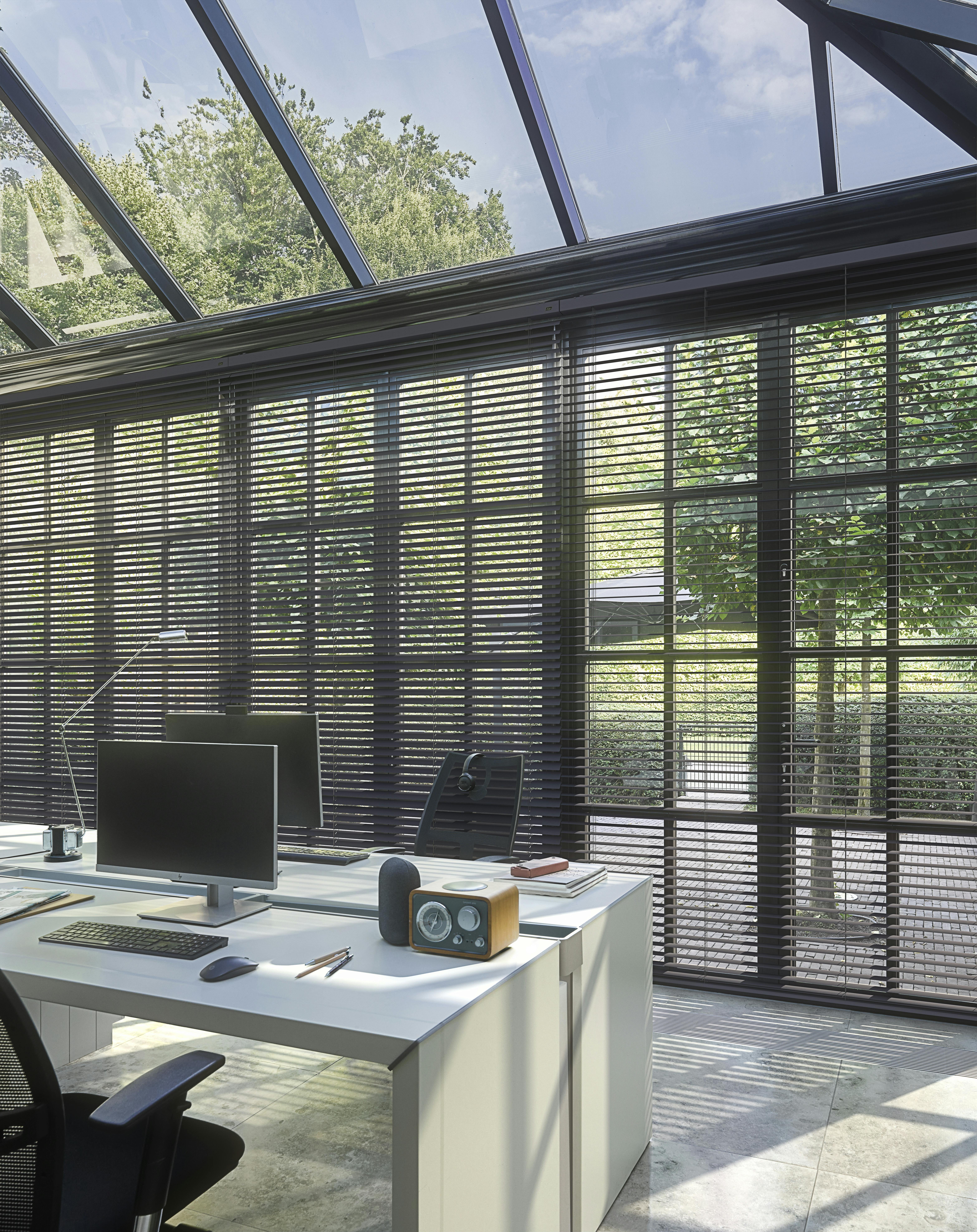 Stores vénitiens bruns dans un bureau à domicile moderne situé dans une véranda
