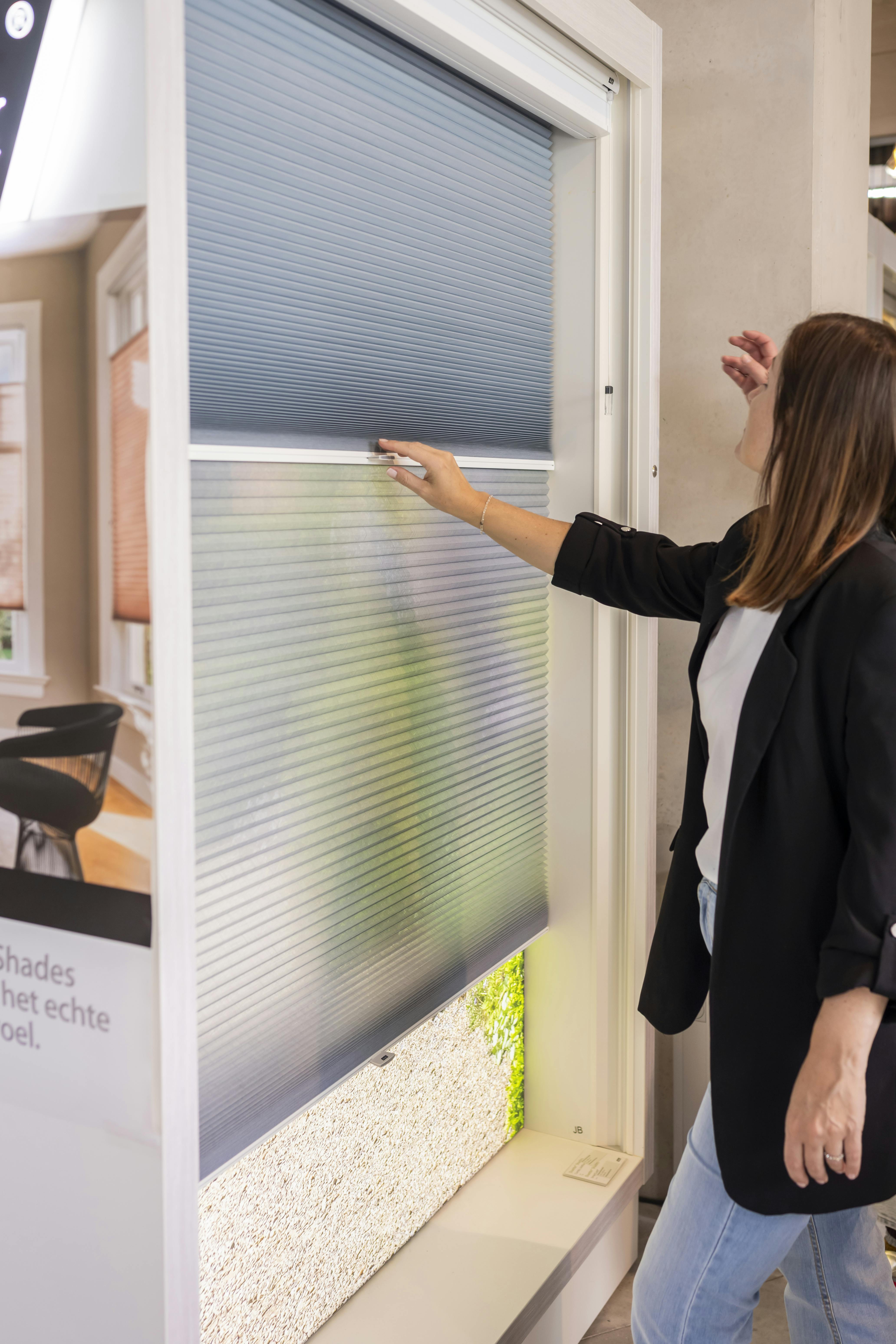 Customer interacting with a blue duette display in a showroom 
