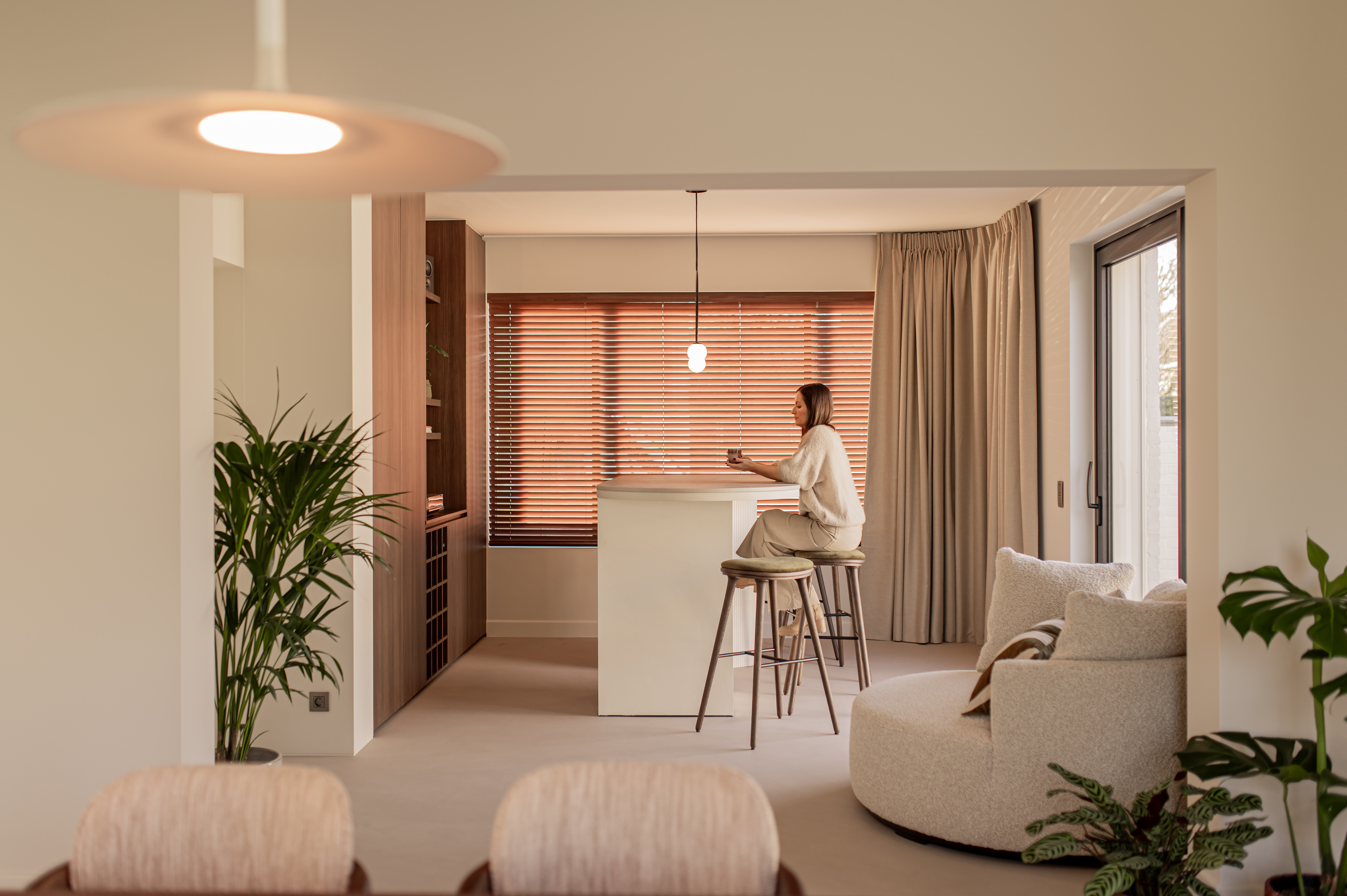 Wood blinds layered with cream curtains in a dining area