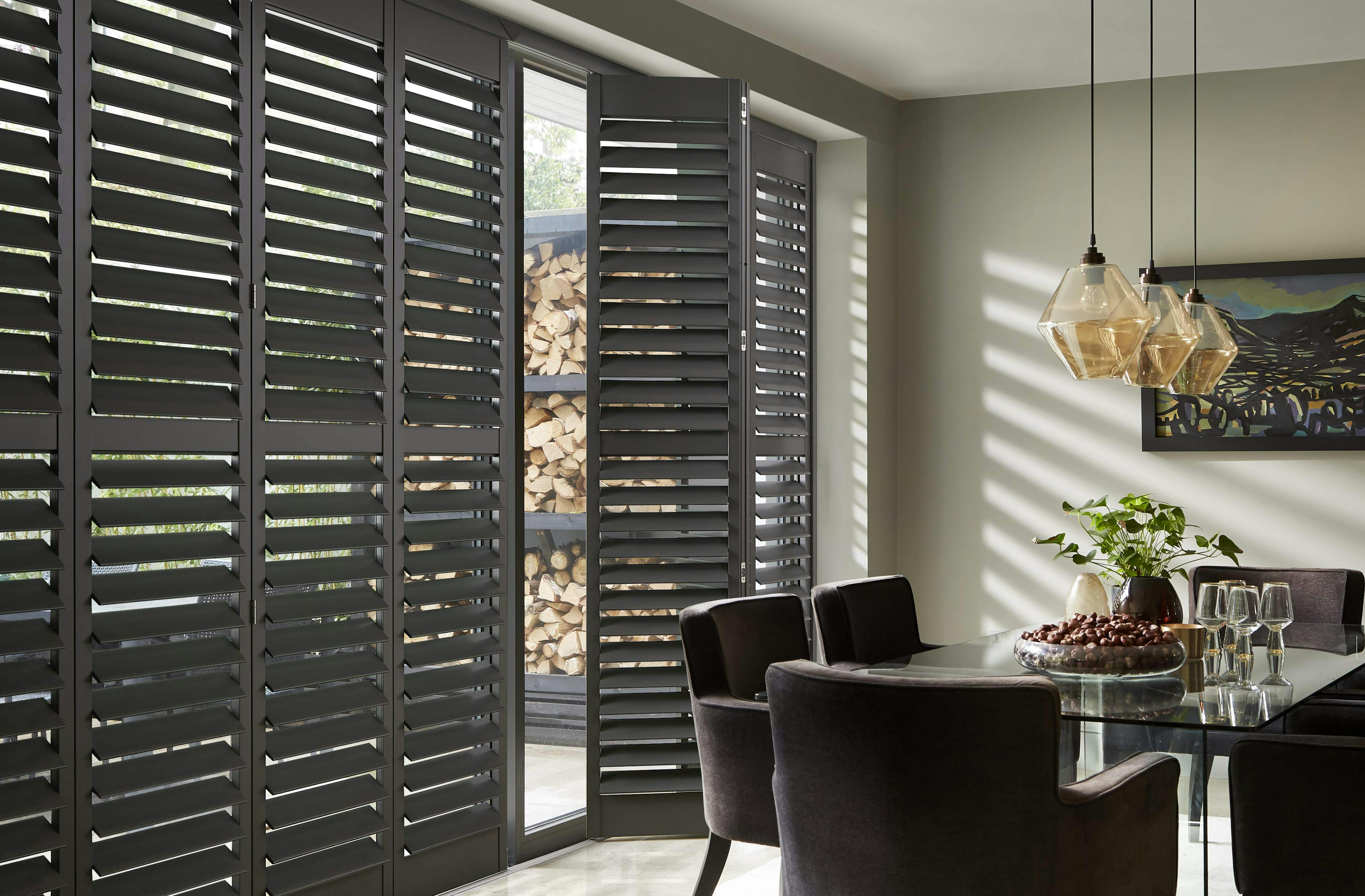Zwarte shutters in een eetkamer