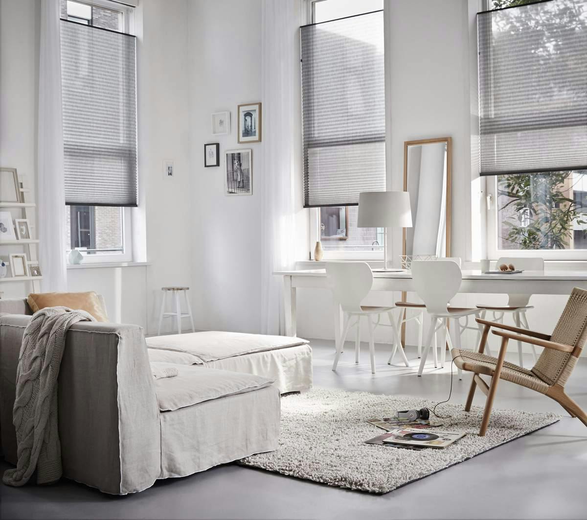 White sheer blinds covering tall living room windows