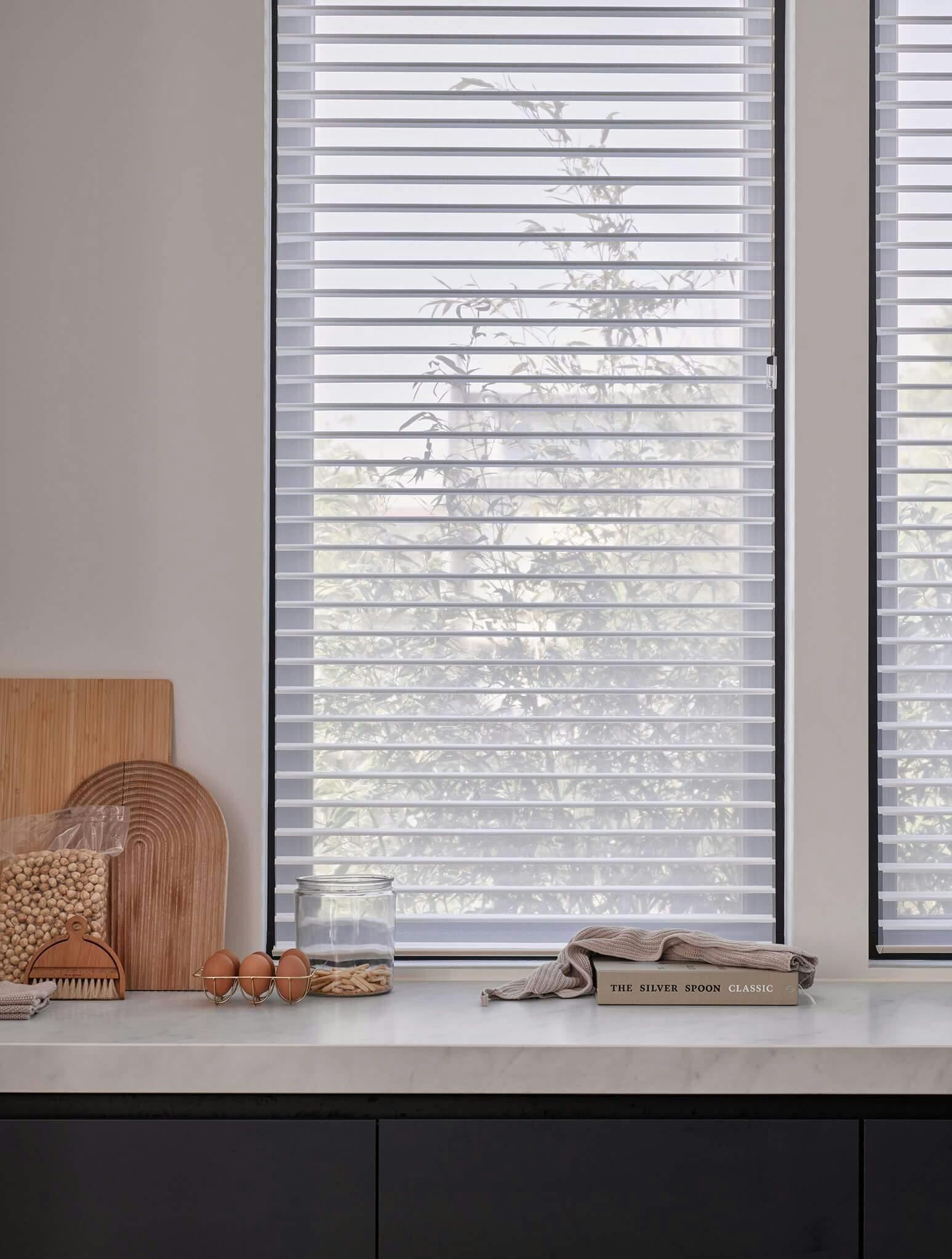 White silhouette shades covering tall kitchen window