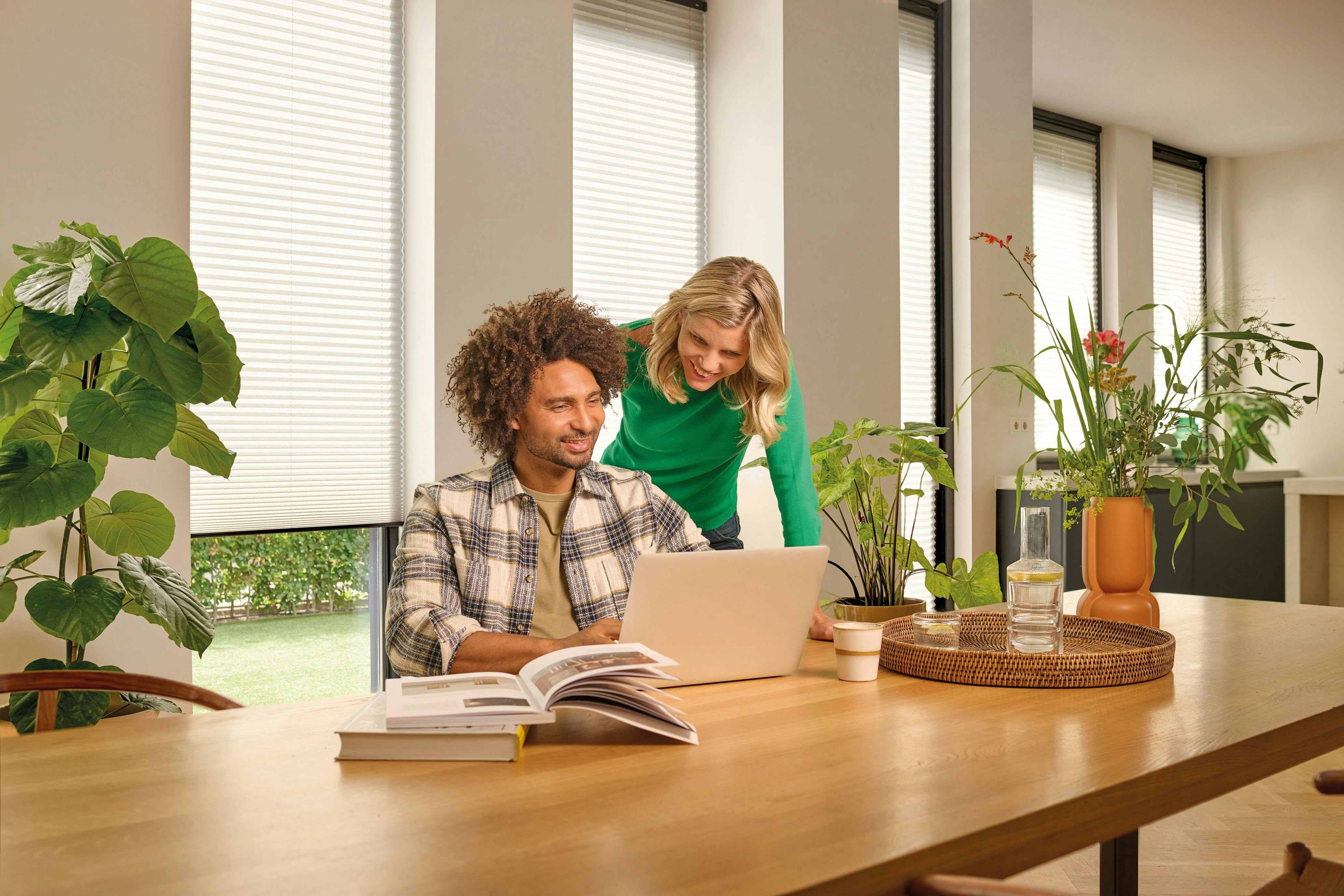Witte plissé shades in een eetkamer met een koppel