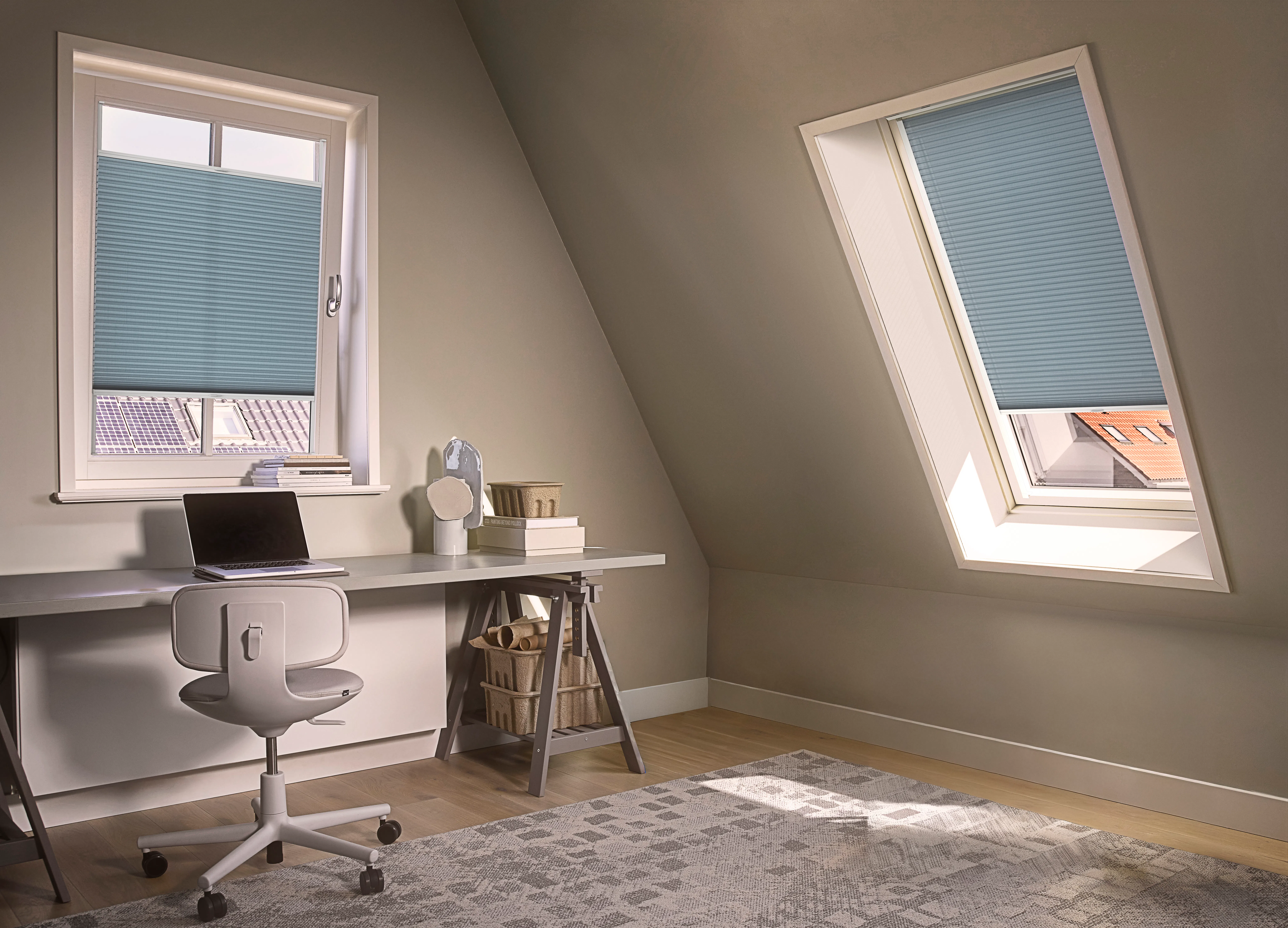 Blue duette shades on a tilt and turn window and skylight window in an attic home office