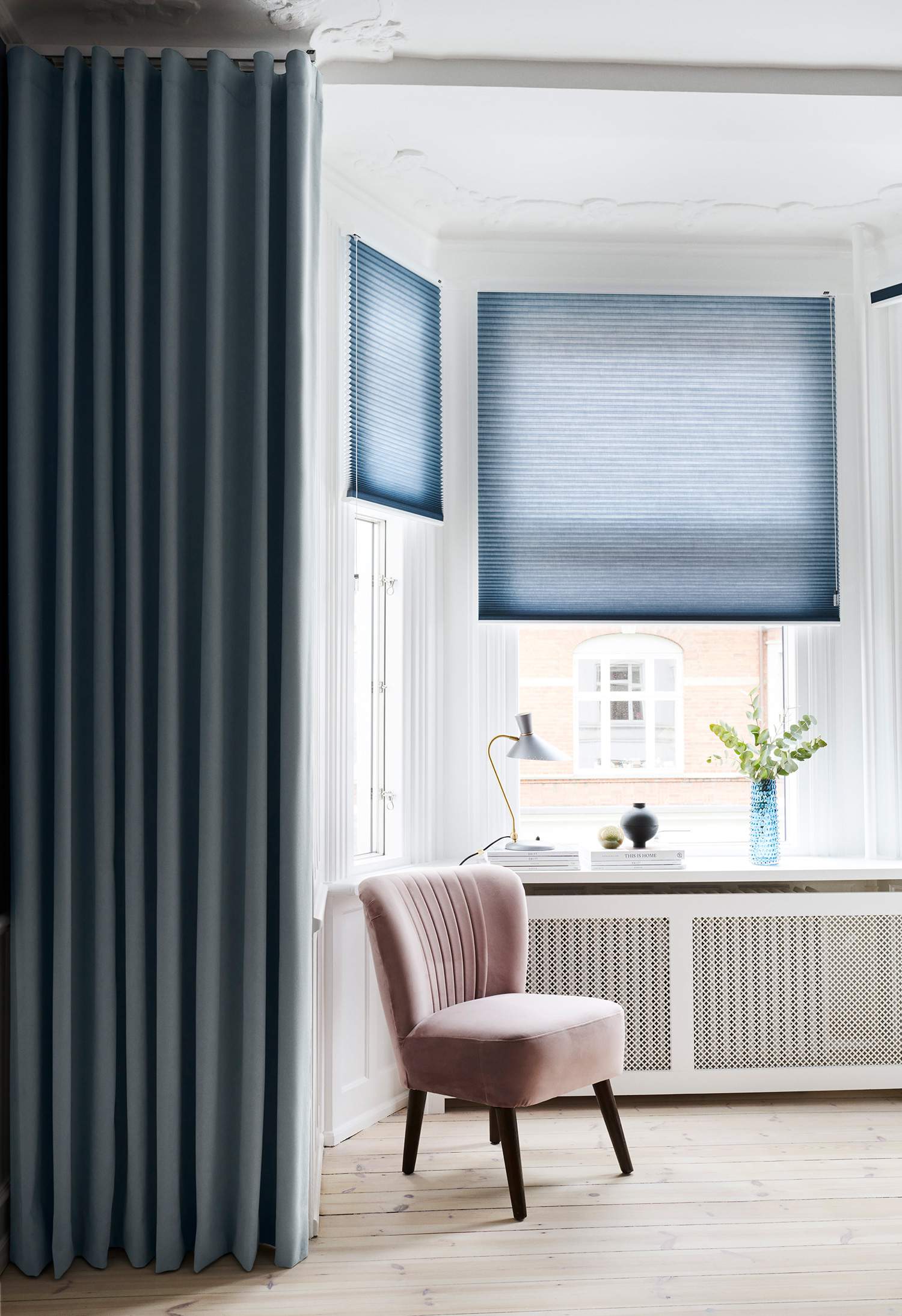 Blue duette blinds covering living room bay windows