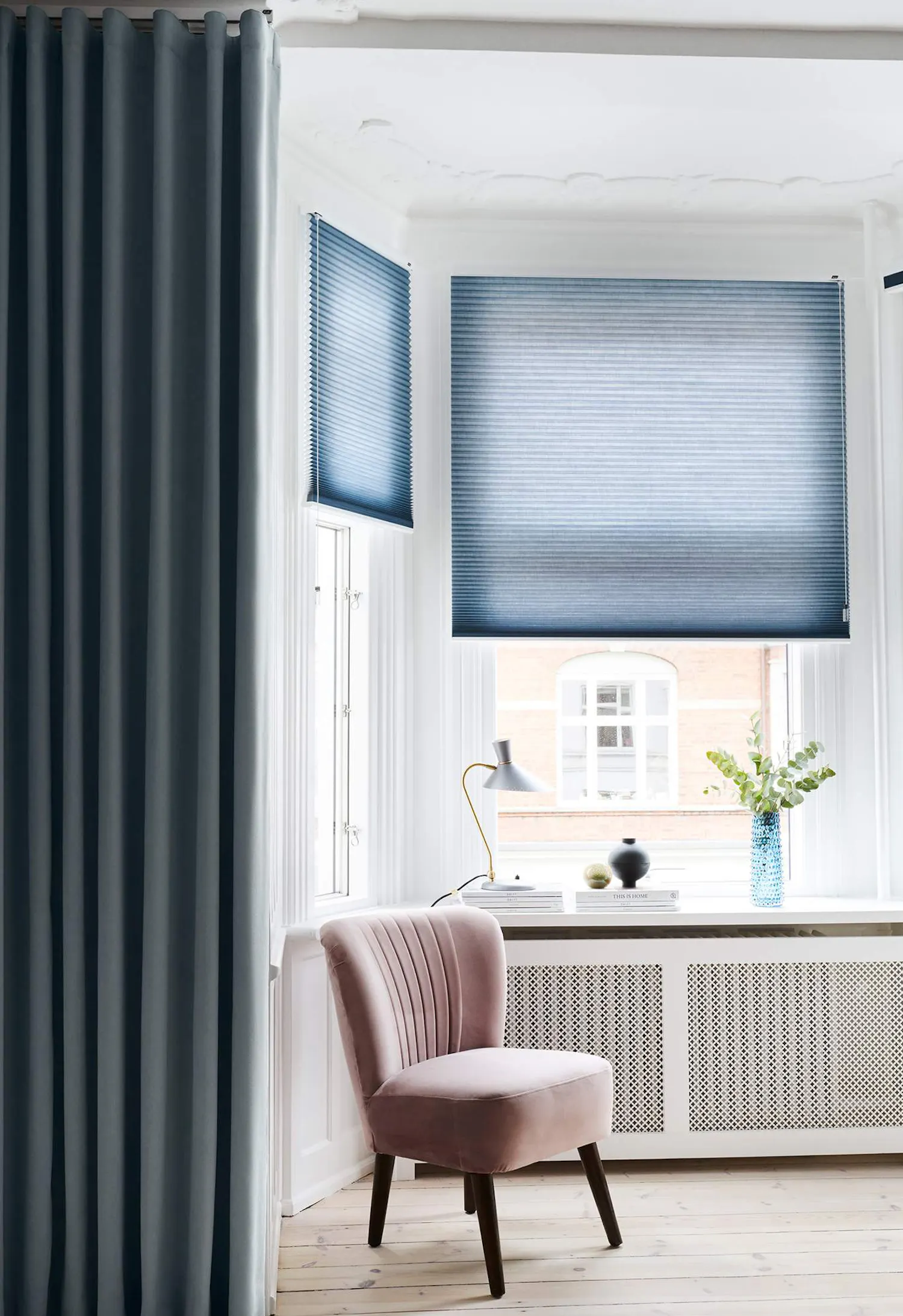 Blue duette blinds covering living room bay windows