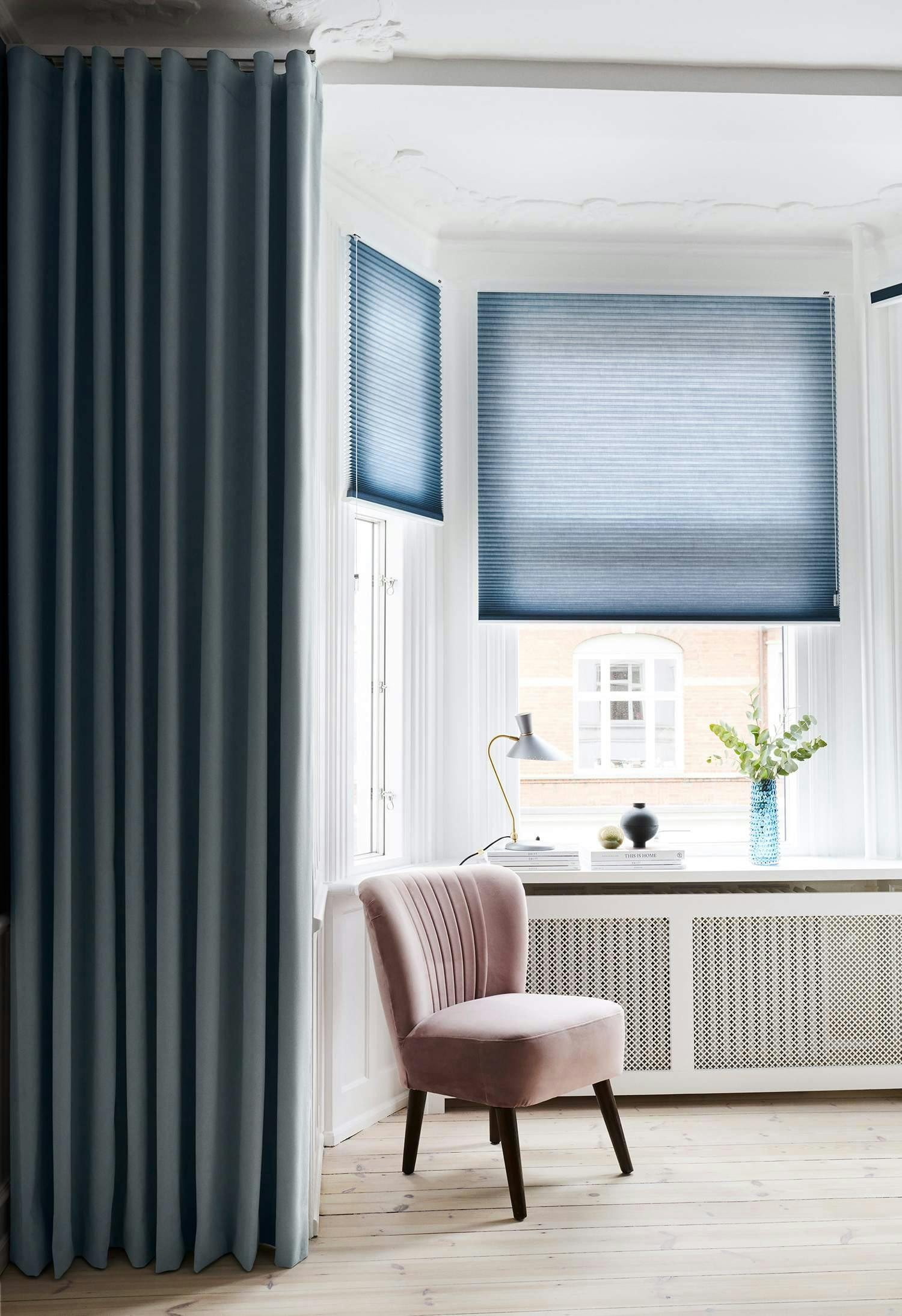 Blue duette blinds covering living room bay windows