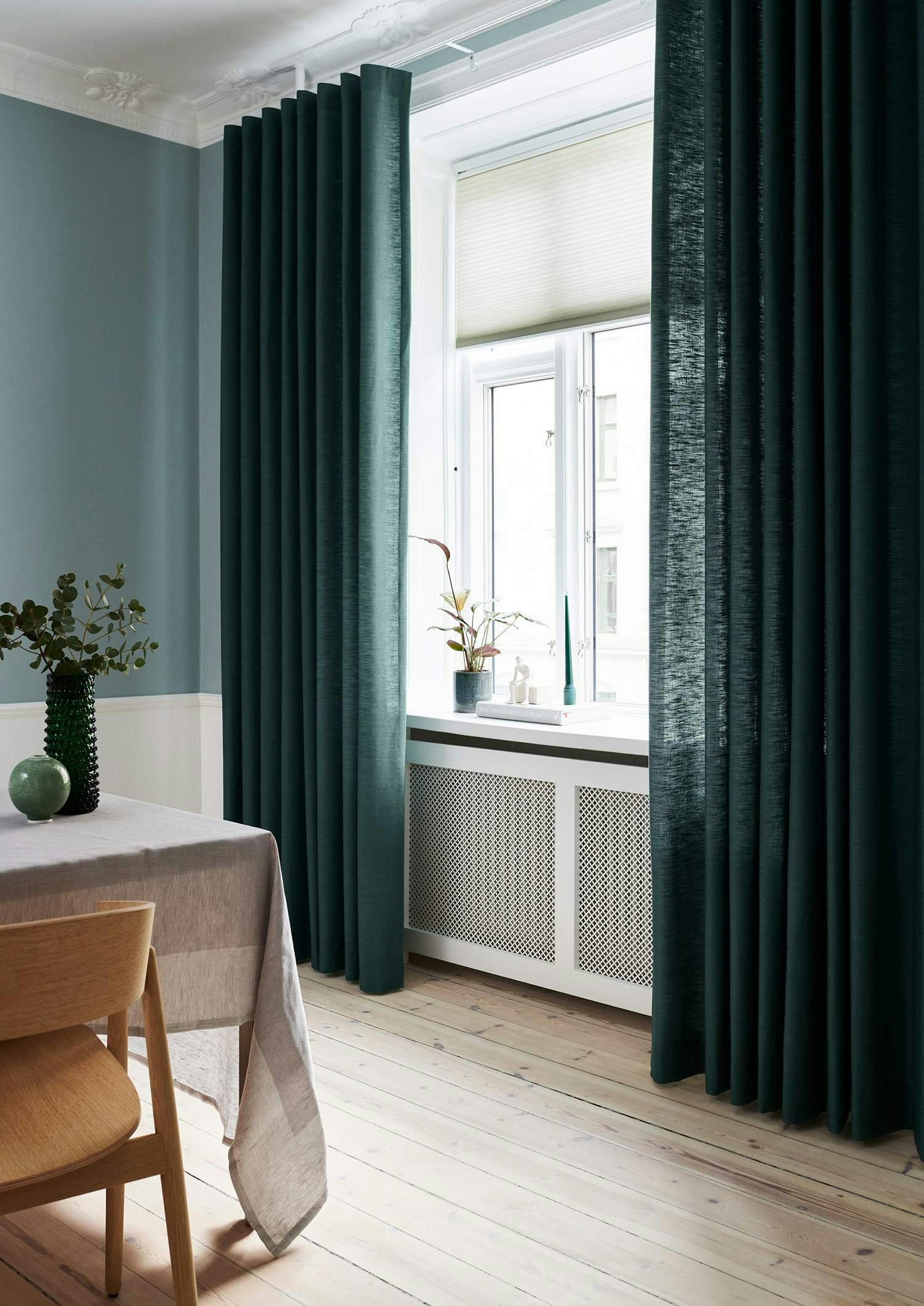 Teal curtains covering dining room windows