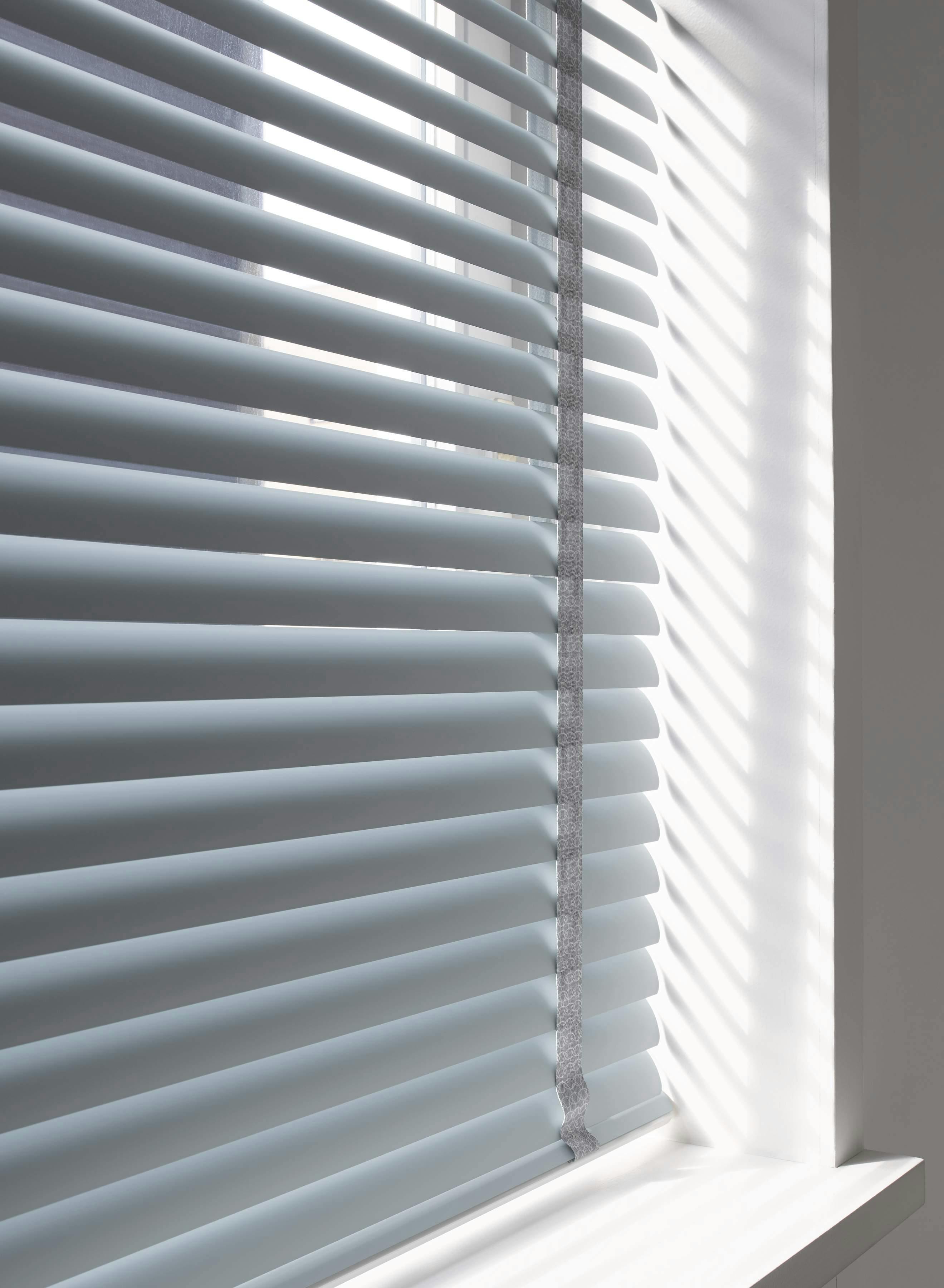 venetian blind covering window in a bright white room