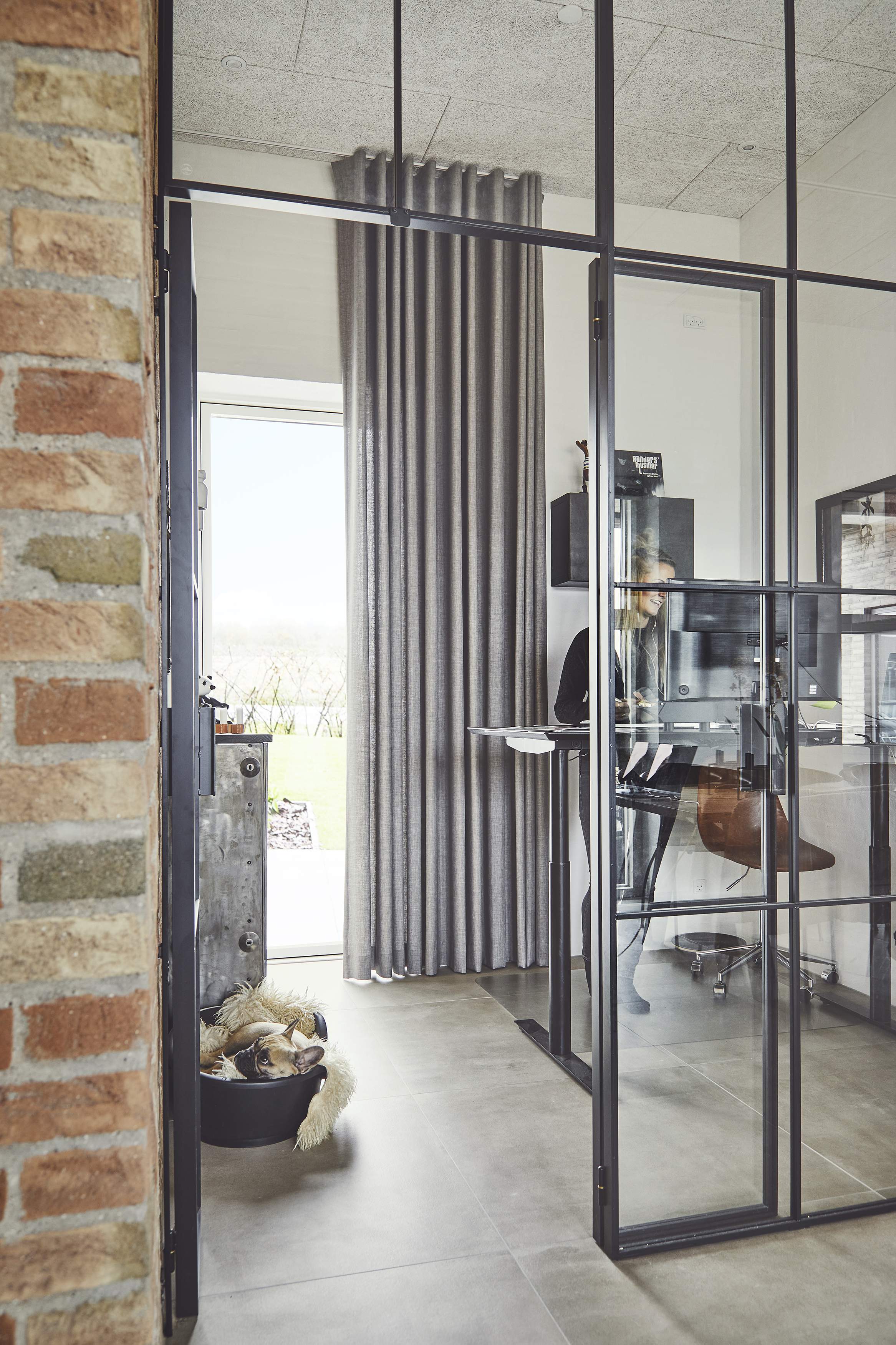 Floor to ceiling curtains covering glass door in a home office