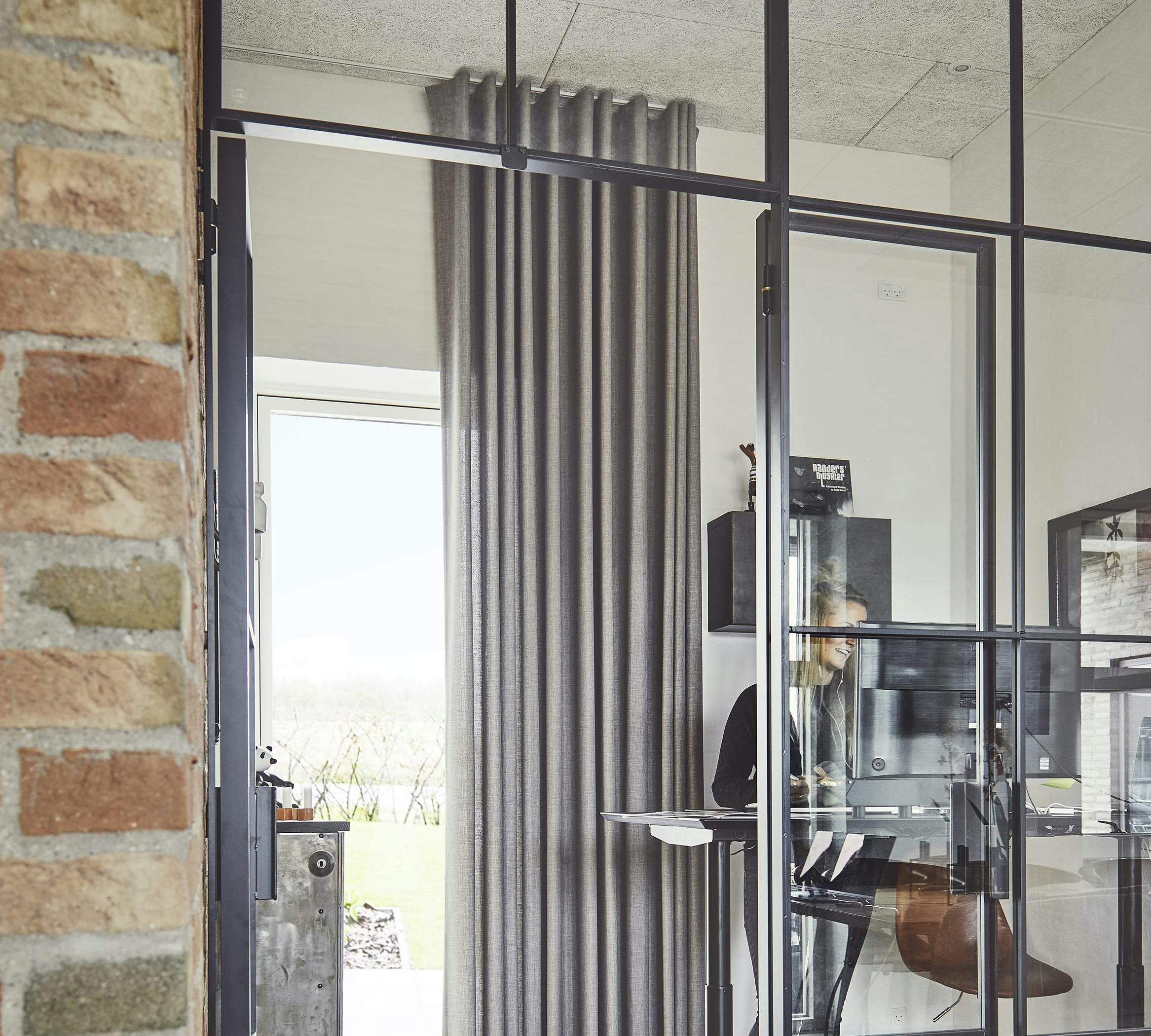 Floor to ceiling curtains covering glass door in a home office