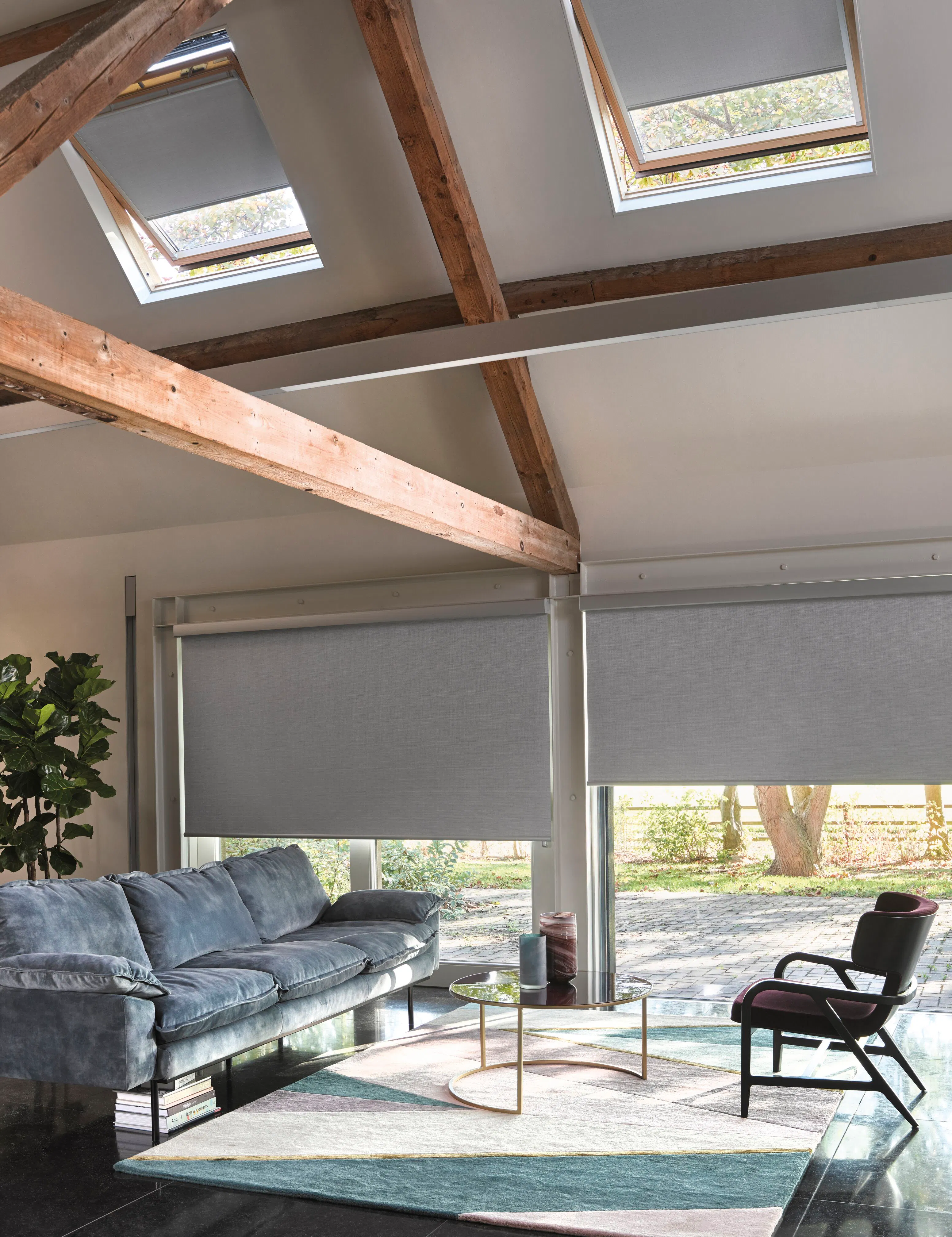Grey roller blinds and grey blackout skylight blinds in living room windows