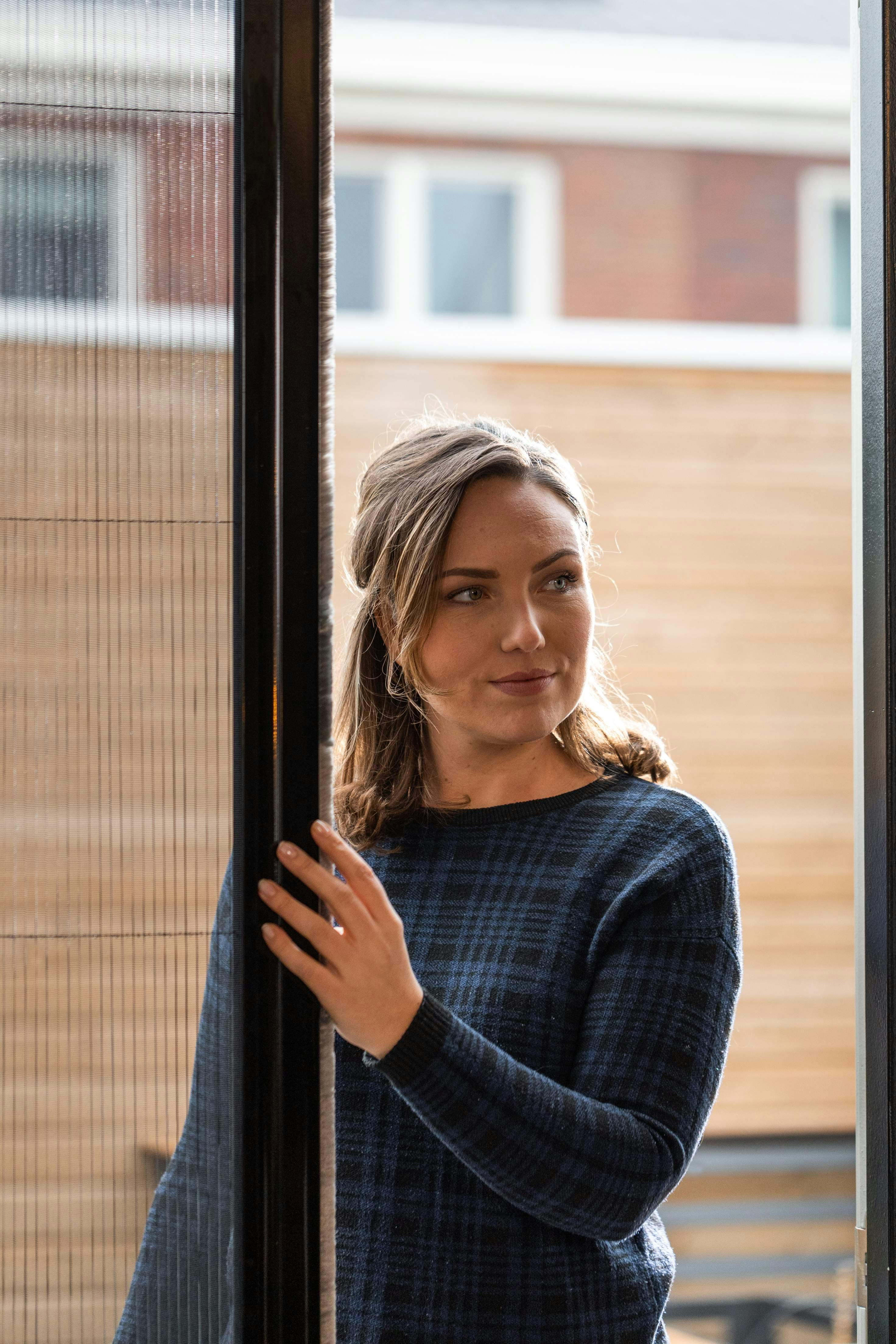 Een vrouw die plissé hordeuren opent