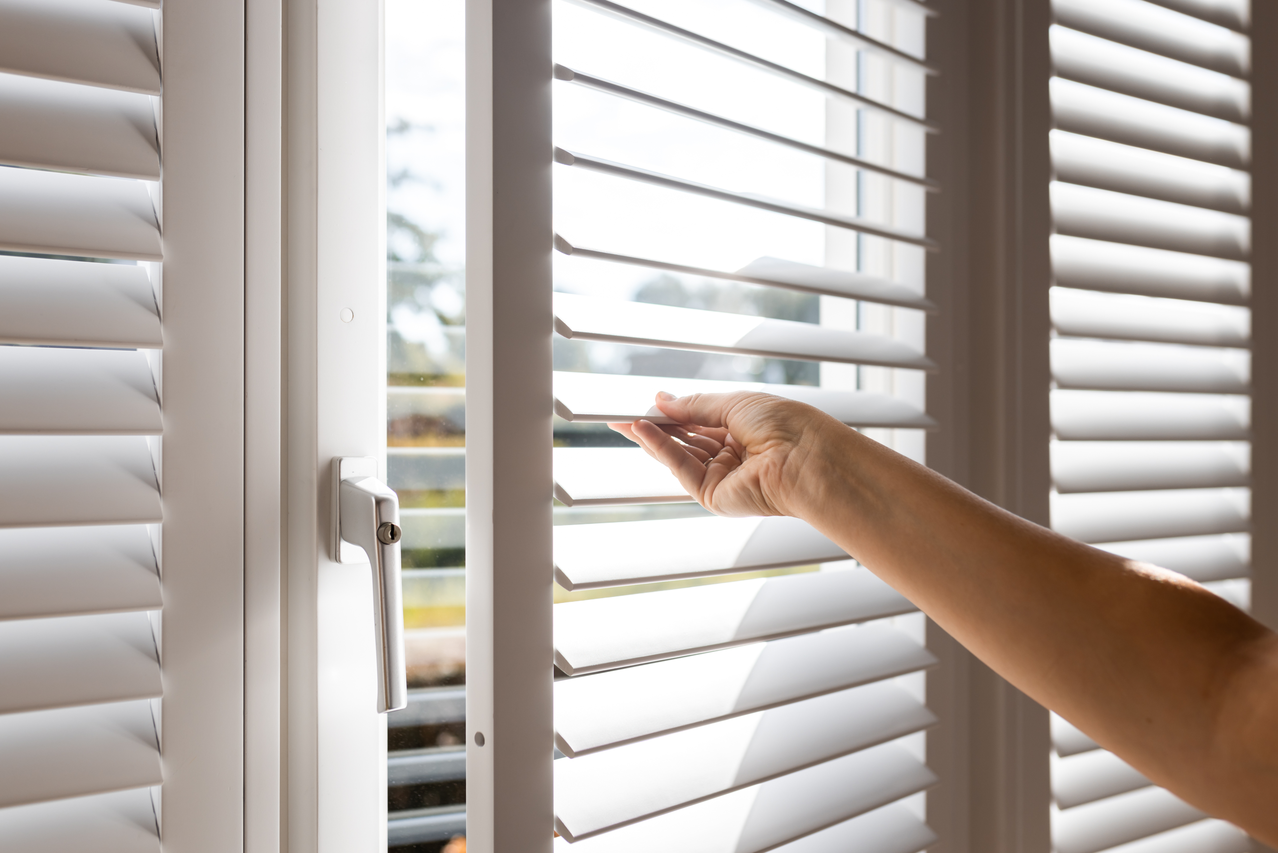 A hand opening a shutter