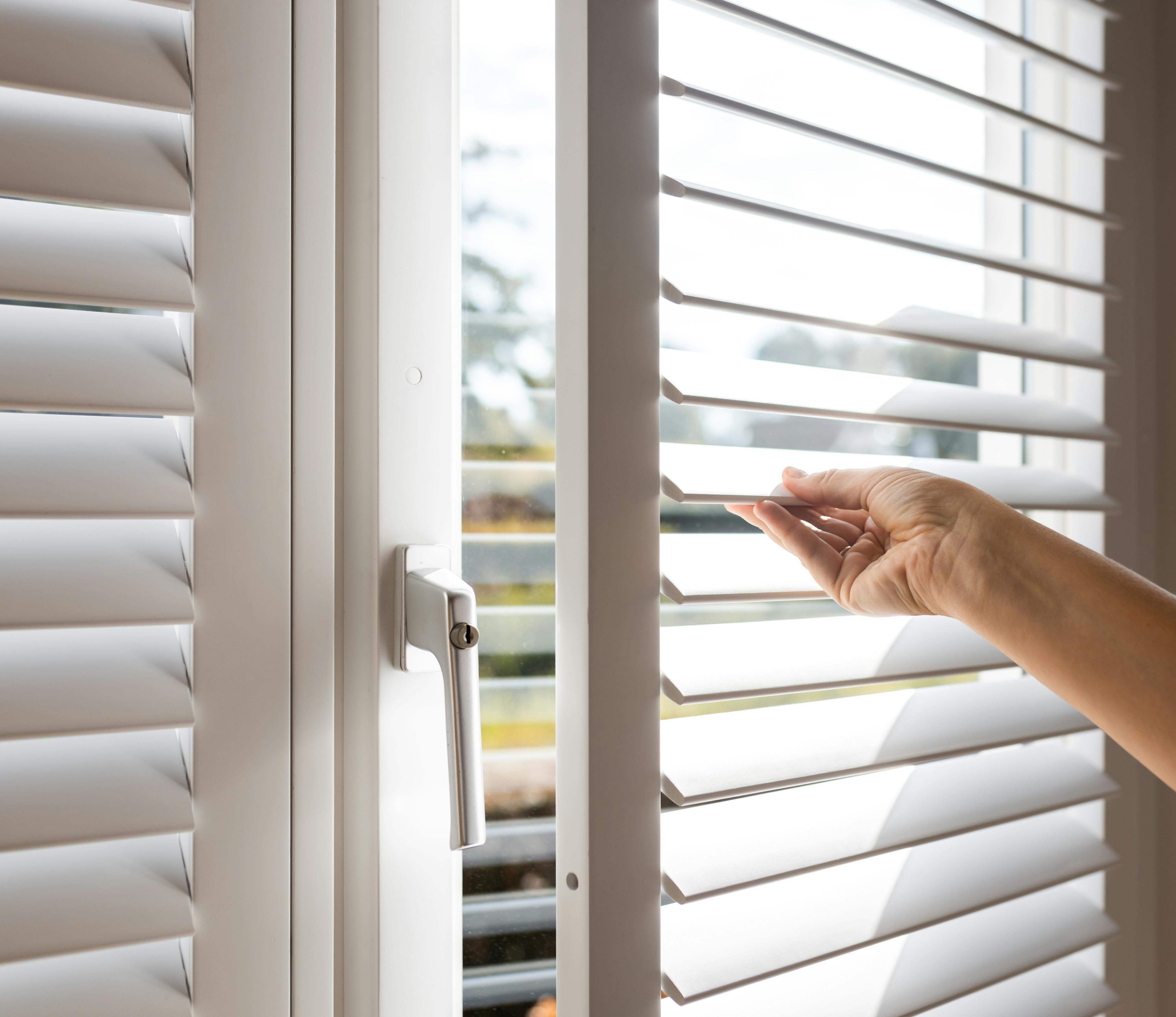 A hand opening a shutter