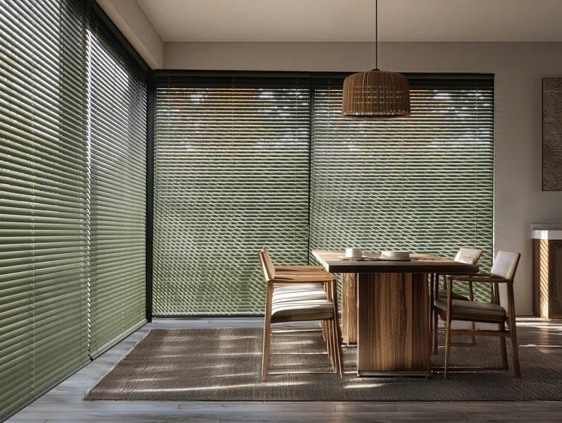 Green venetian blinds on large sliding patio doors in a dining room 