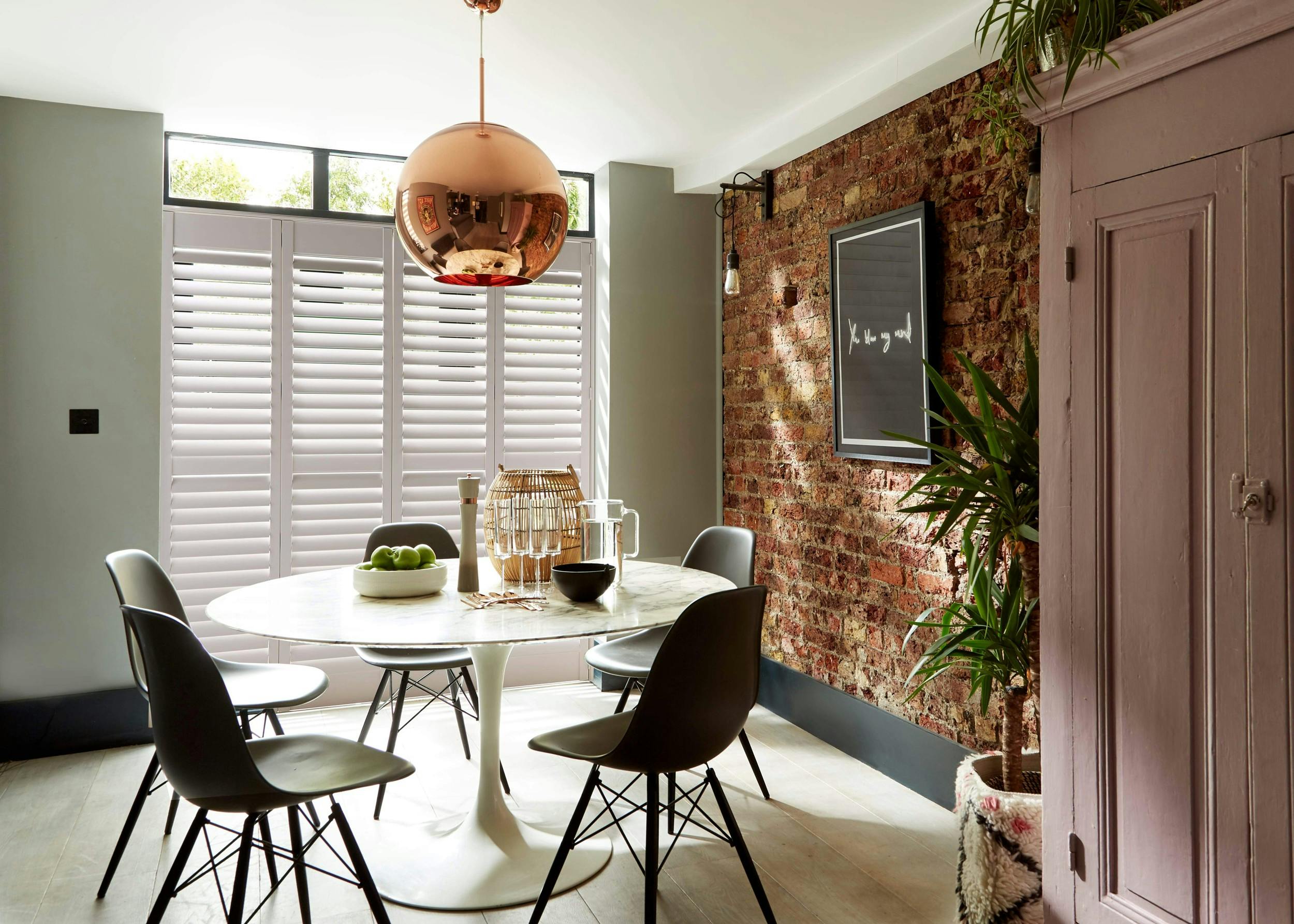Sunny dining room with white Shutters on windows 