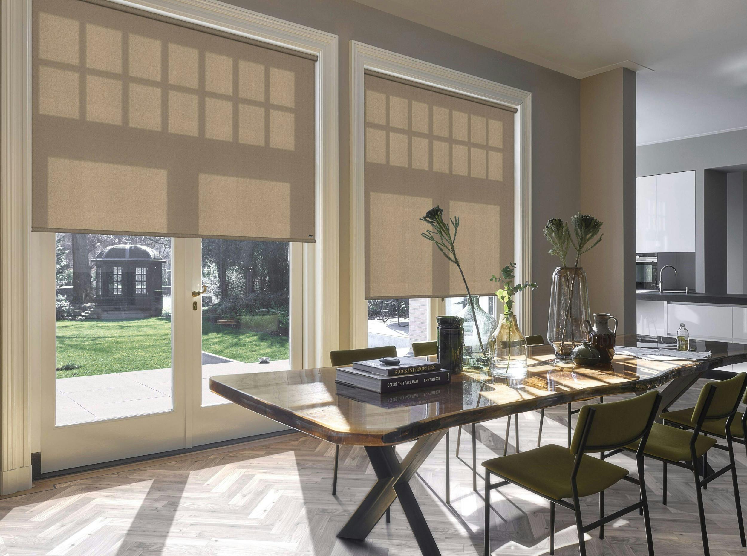 Light dining room with cream acoustic roller blinds o windows and patio doors