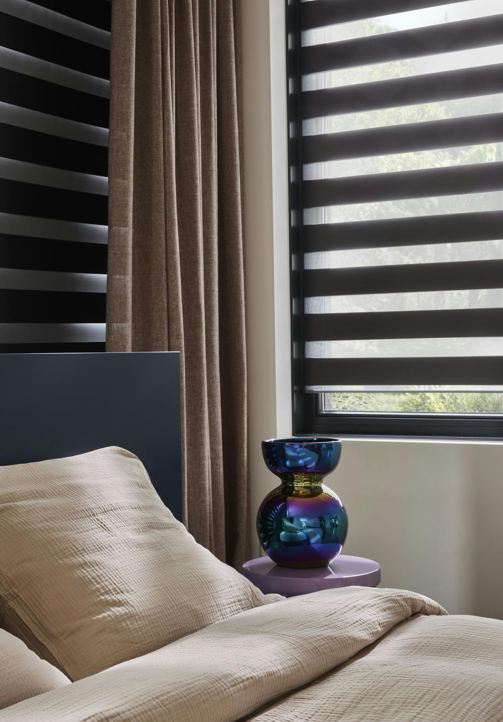 Bedroom with black duo roller blinds