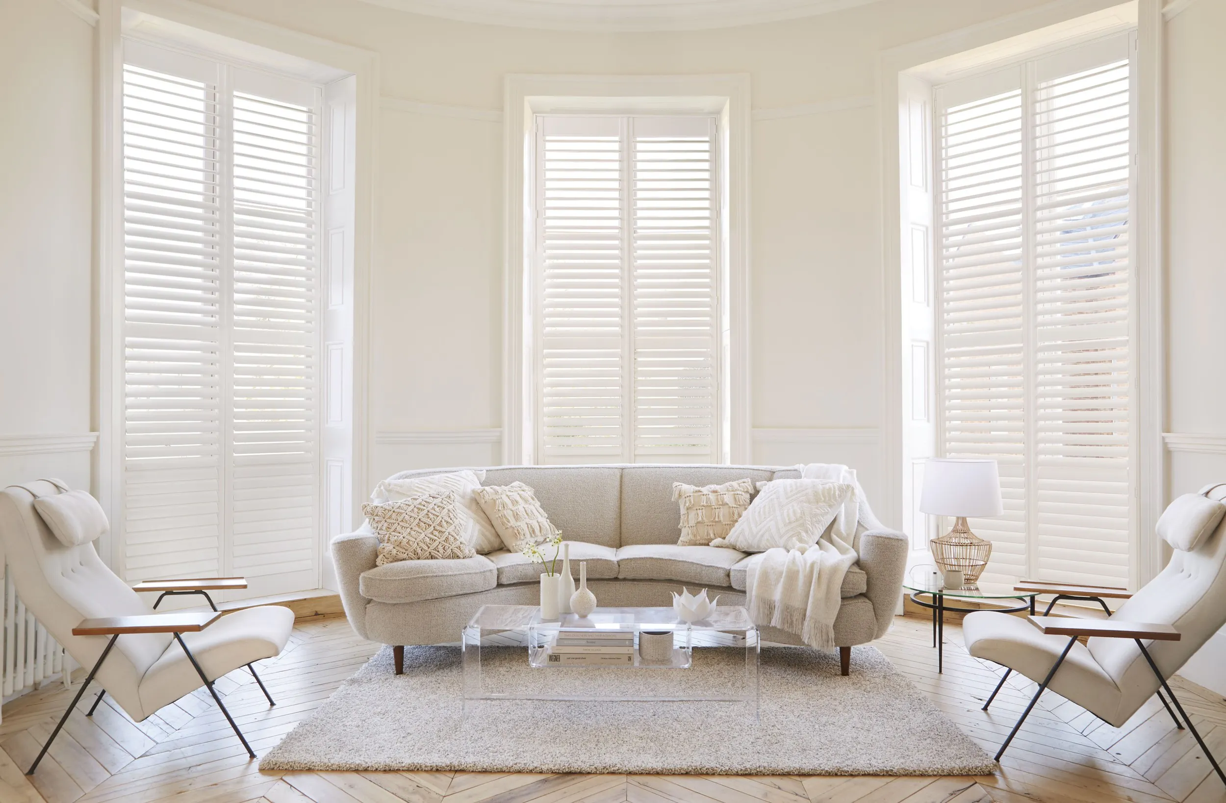 White living room with white shutters on bay windows