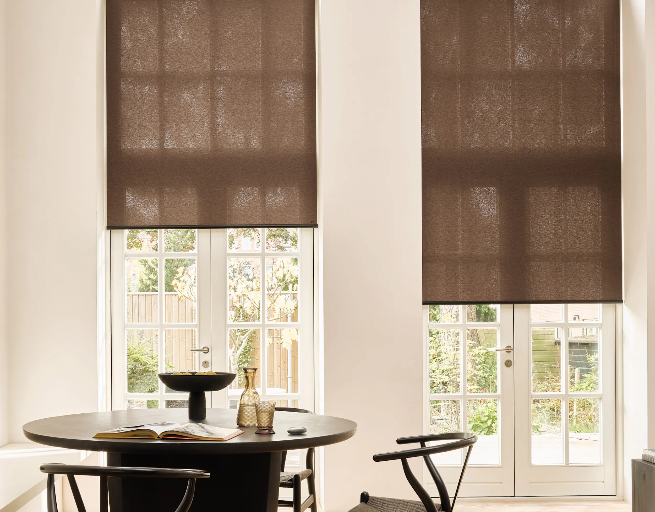 Modern living room with brown roller blinds on a window and patio door