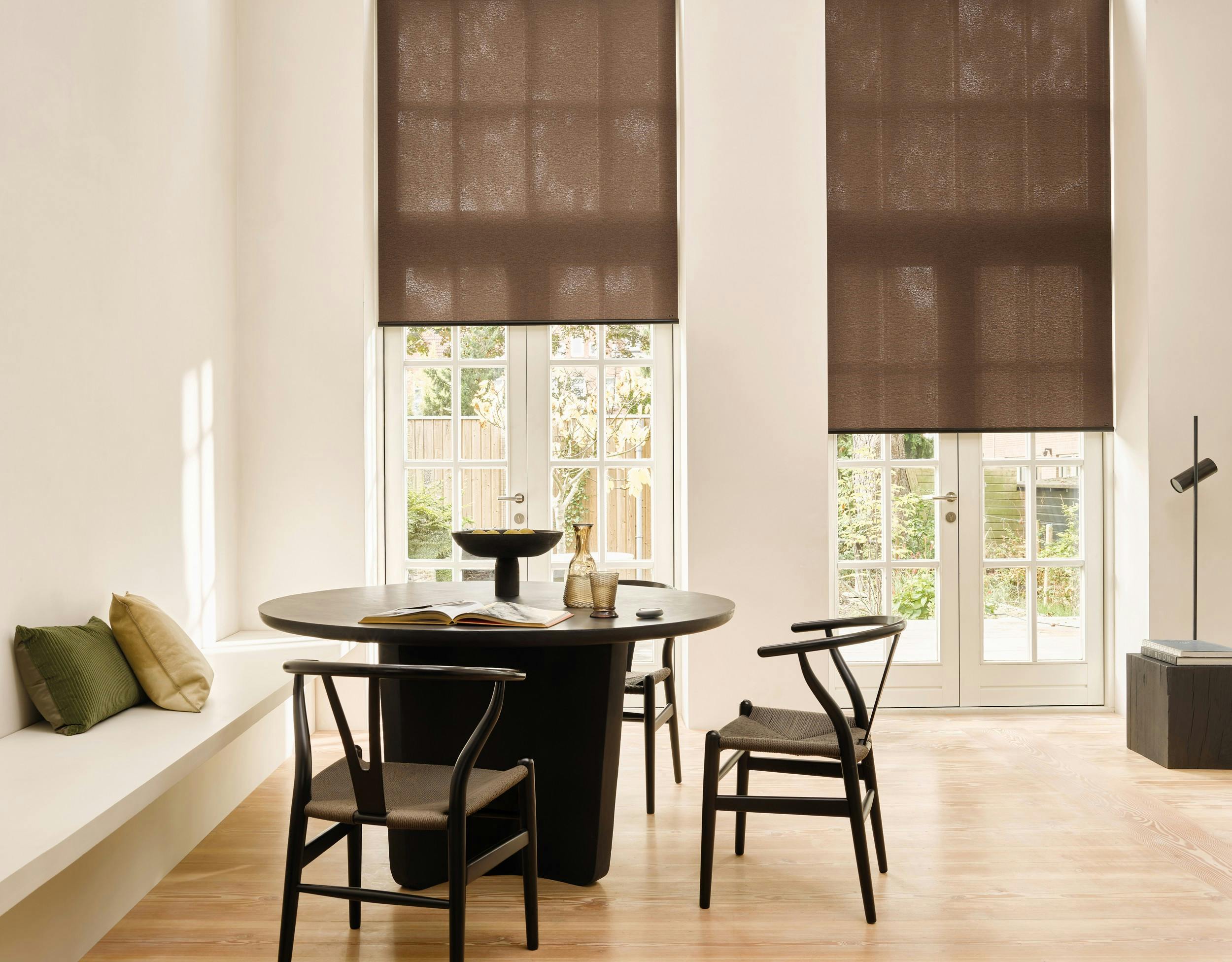 Modern living room with brown roller blinds on a window and patio door